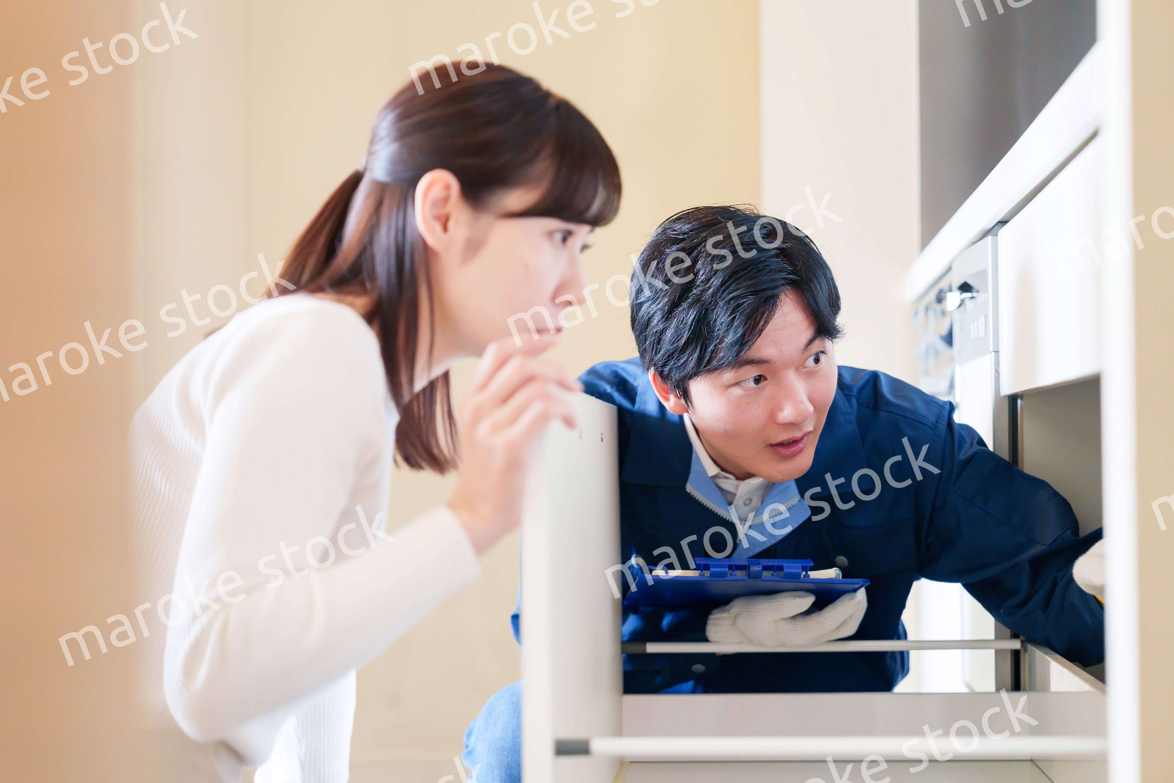 修理業者に家の修理をお願いする女性