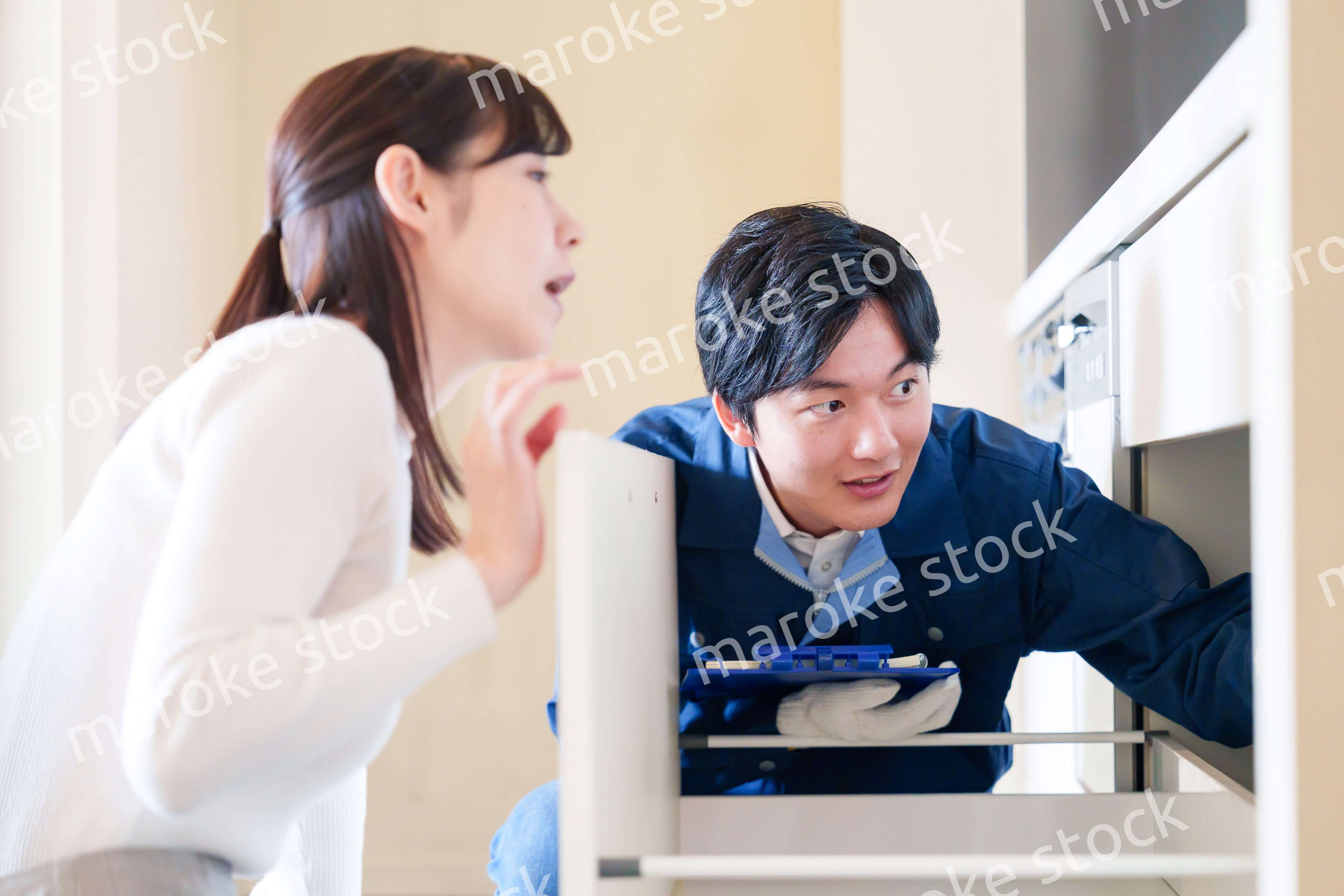 修理業者に家の修理をお願いする女性