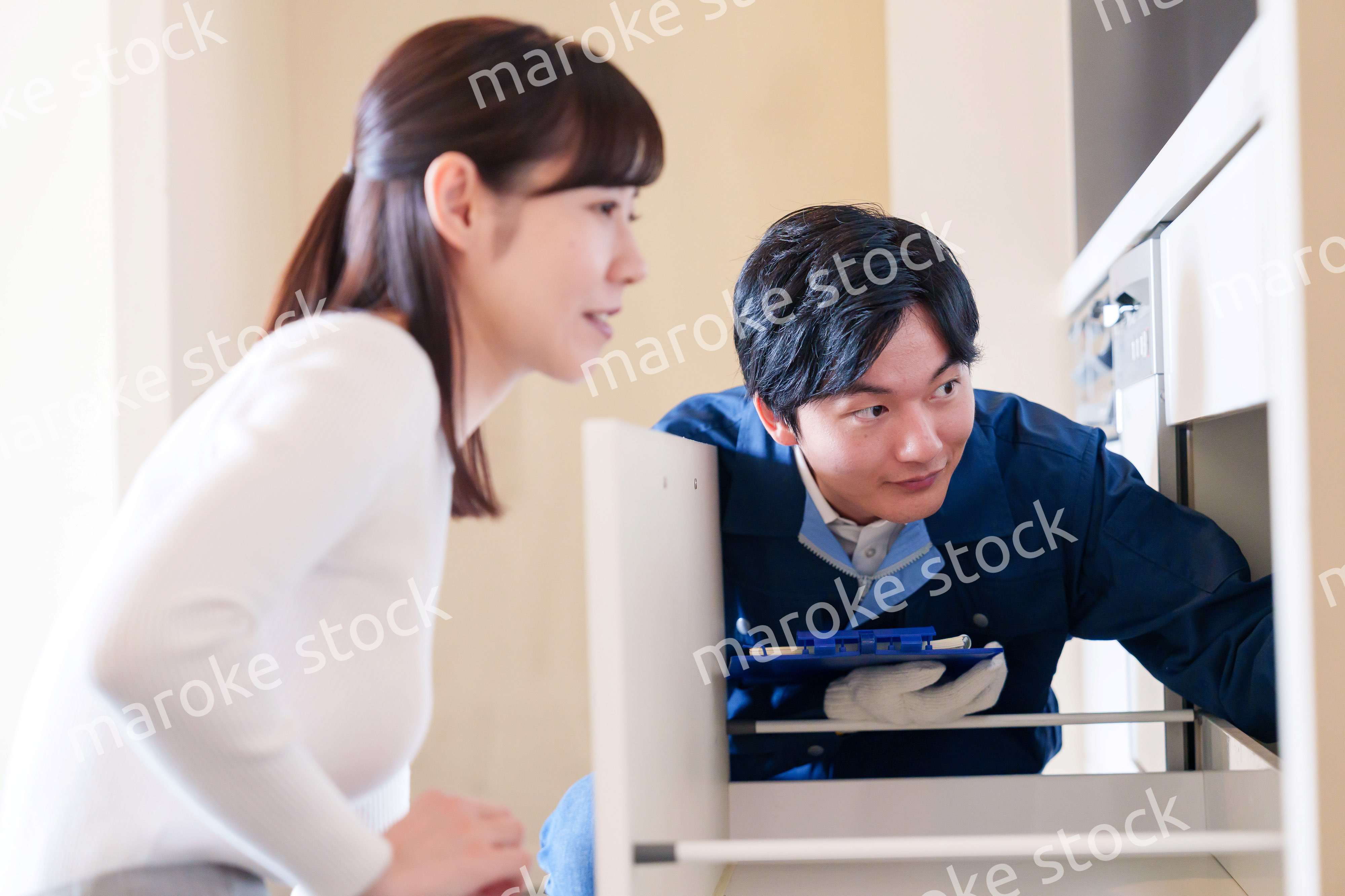 修理業者に家の修理をお願いする女性