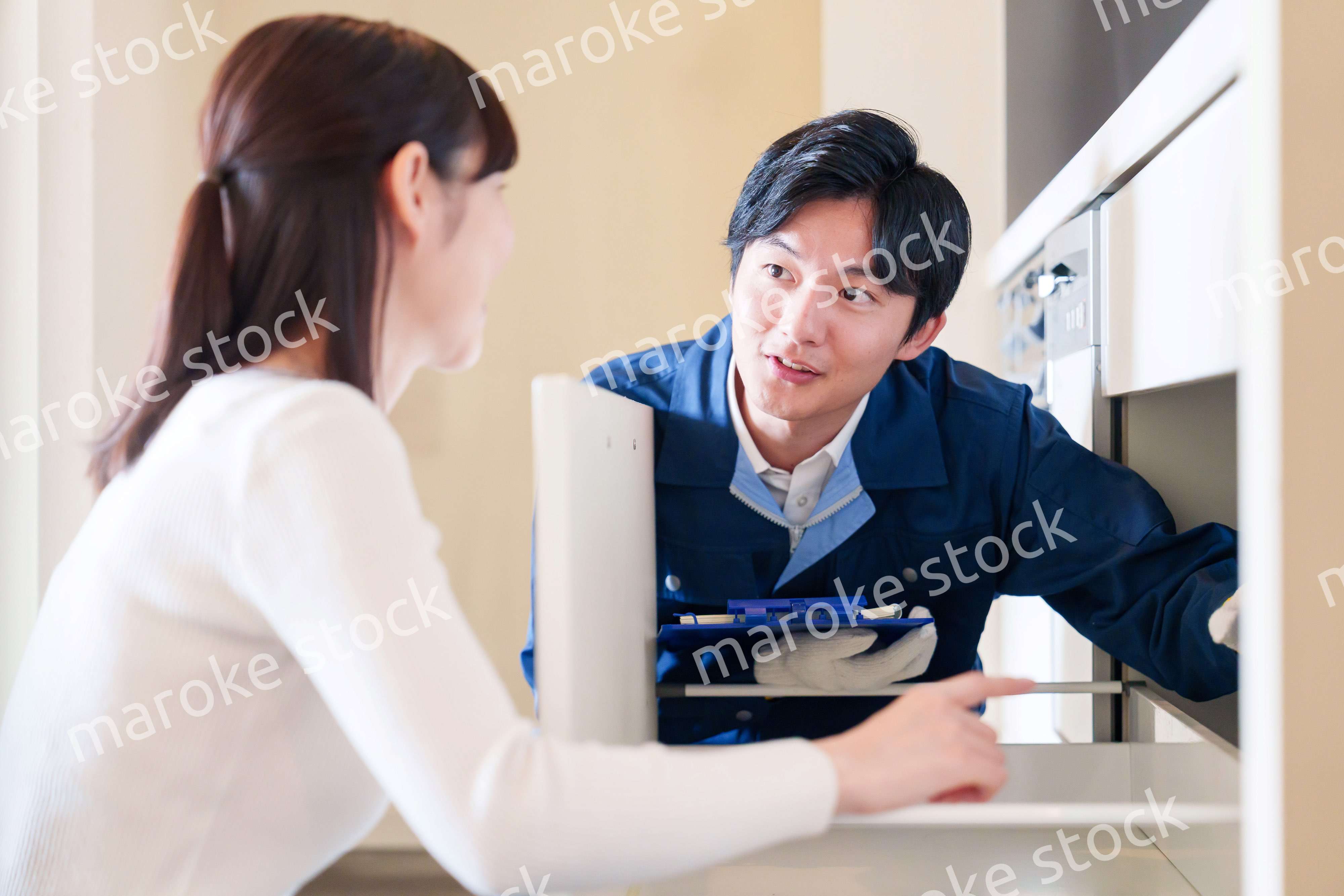 修理業者に家の修理をお願いする女性