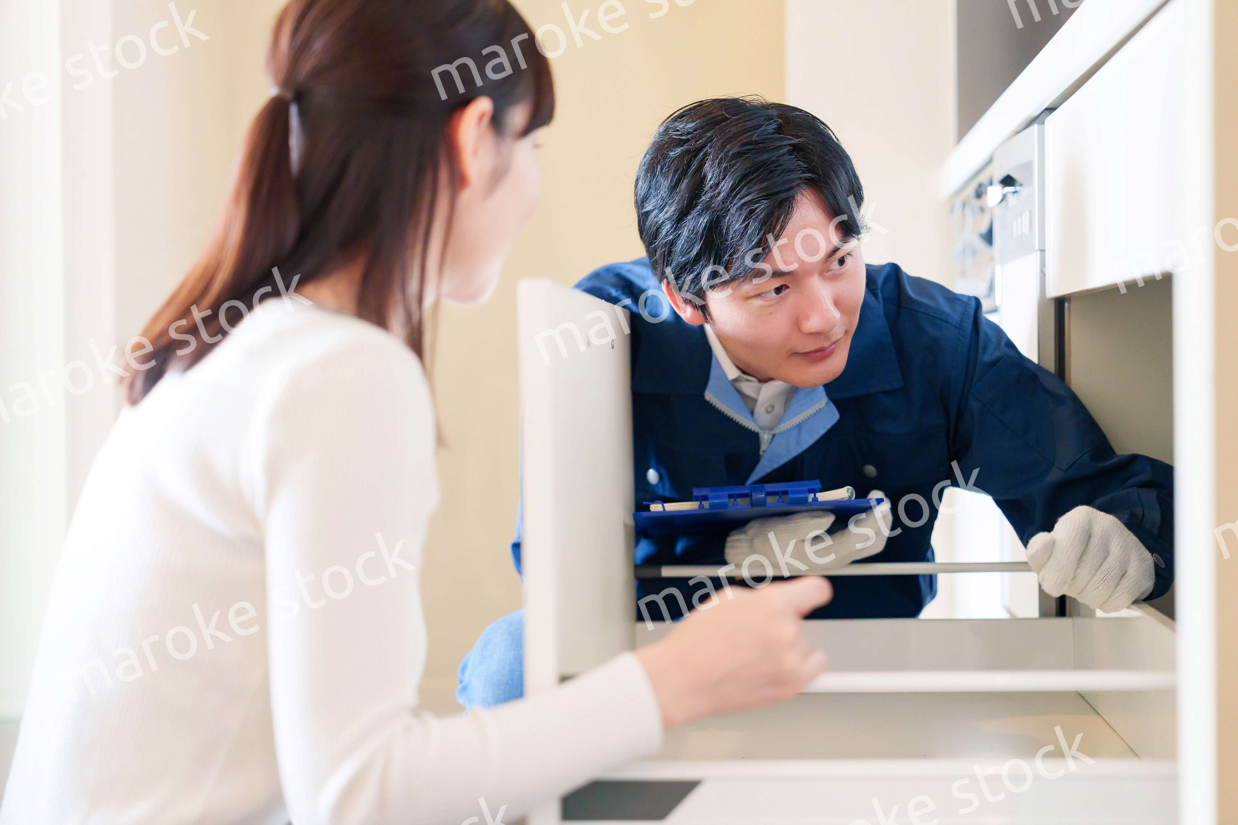 修理業者に家の修理をお願いする女性