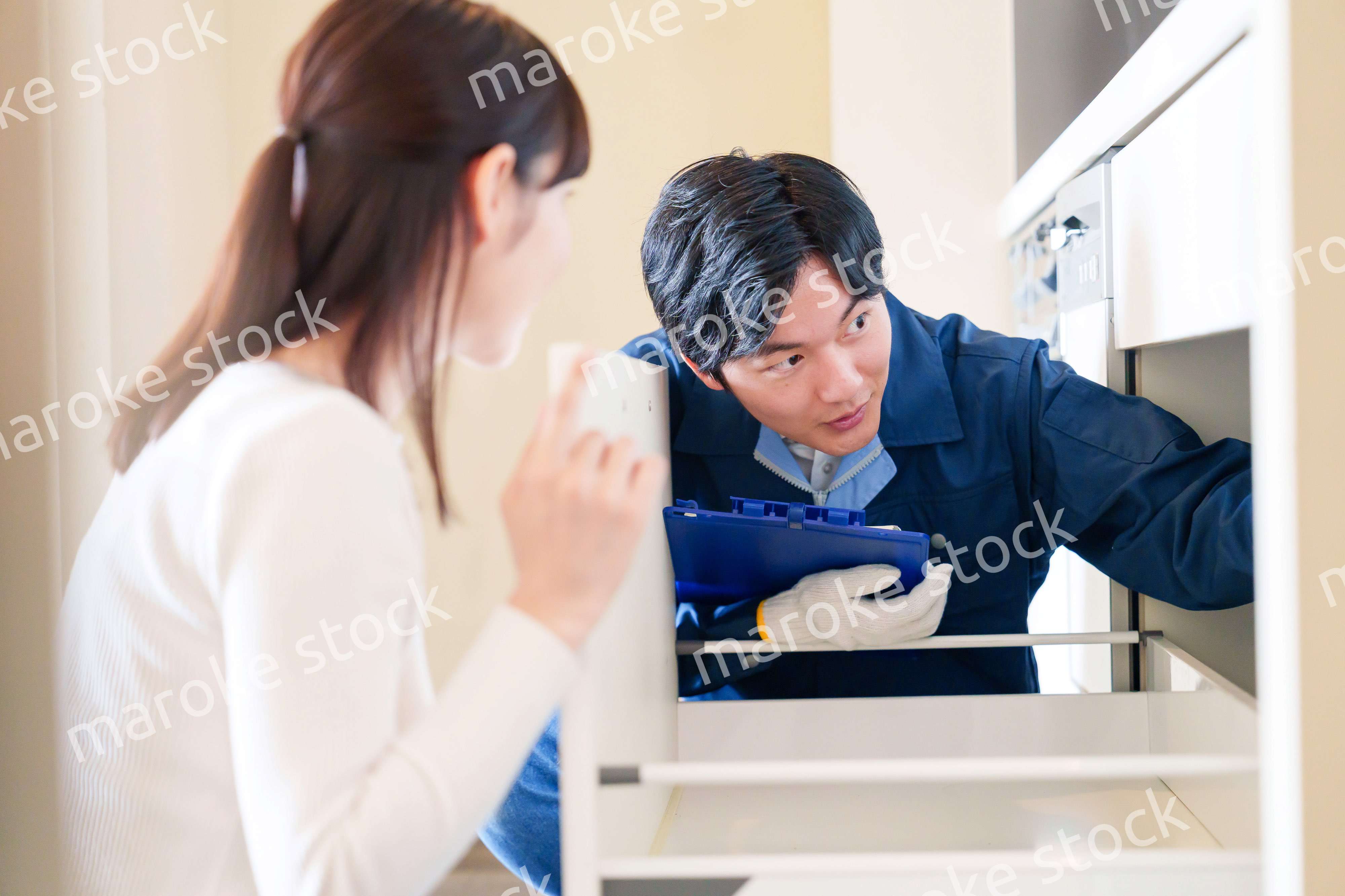 修理業者に家の修理をお願いする女性