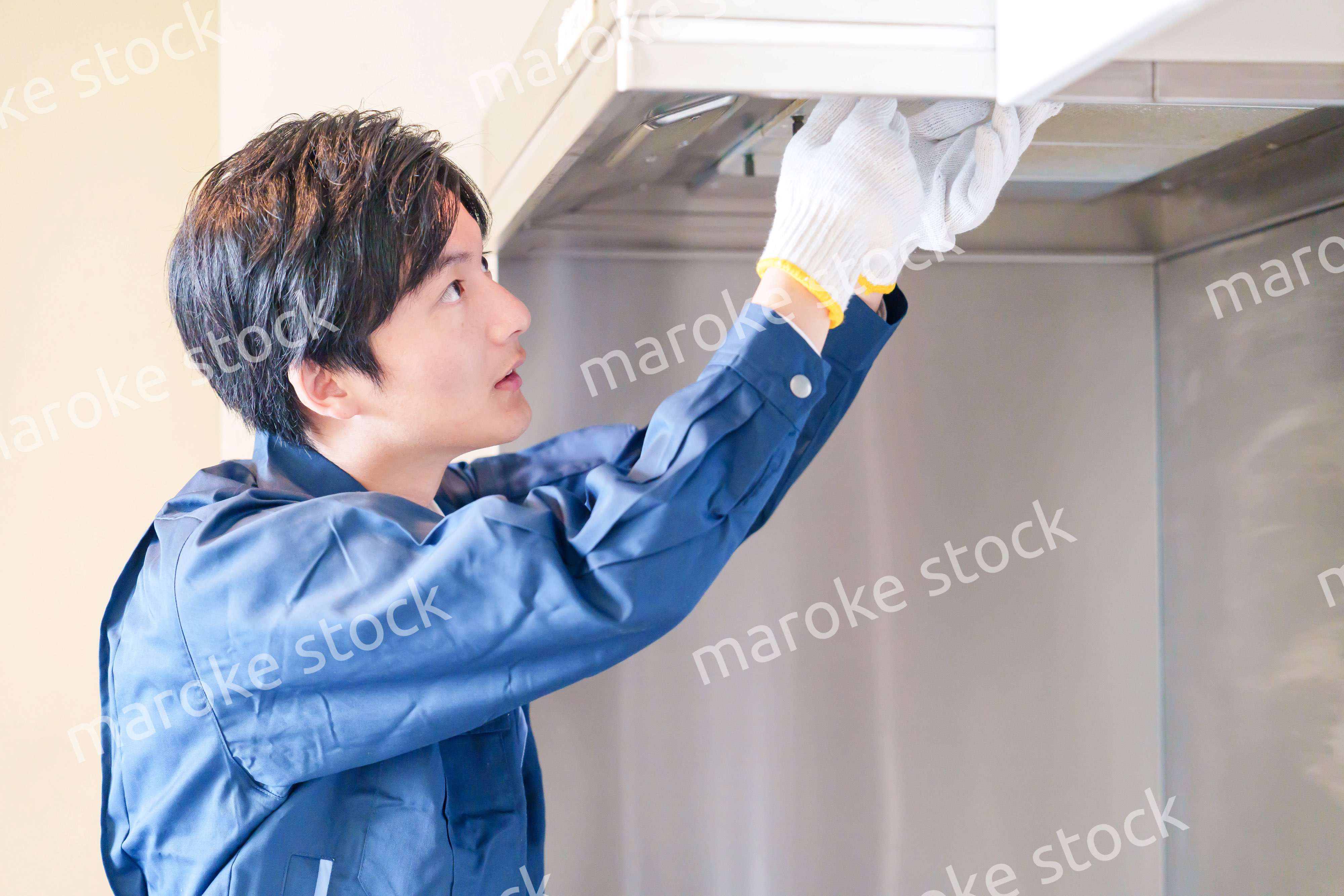 レンジフードのクリーニングをする男性の作業員