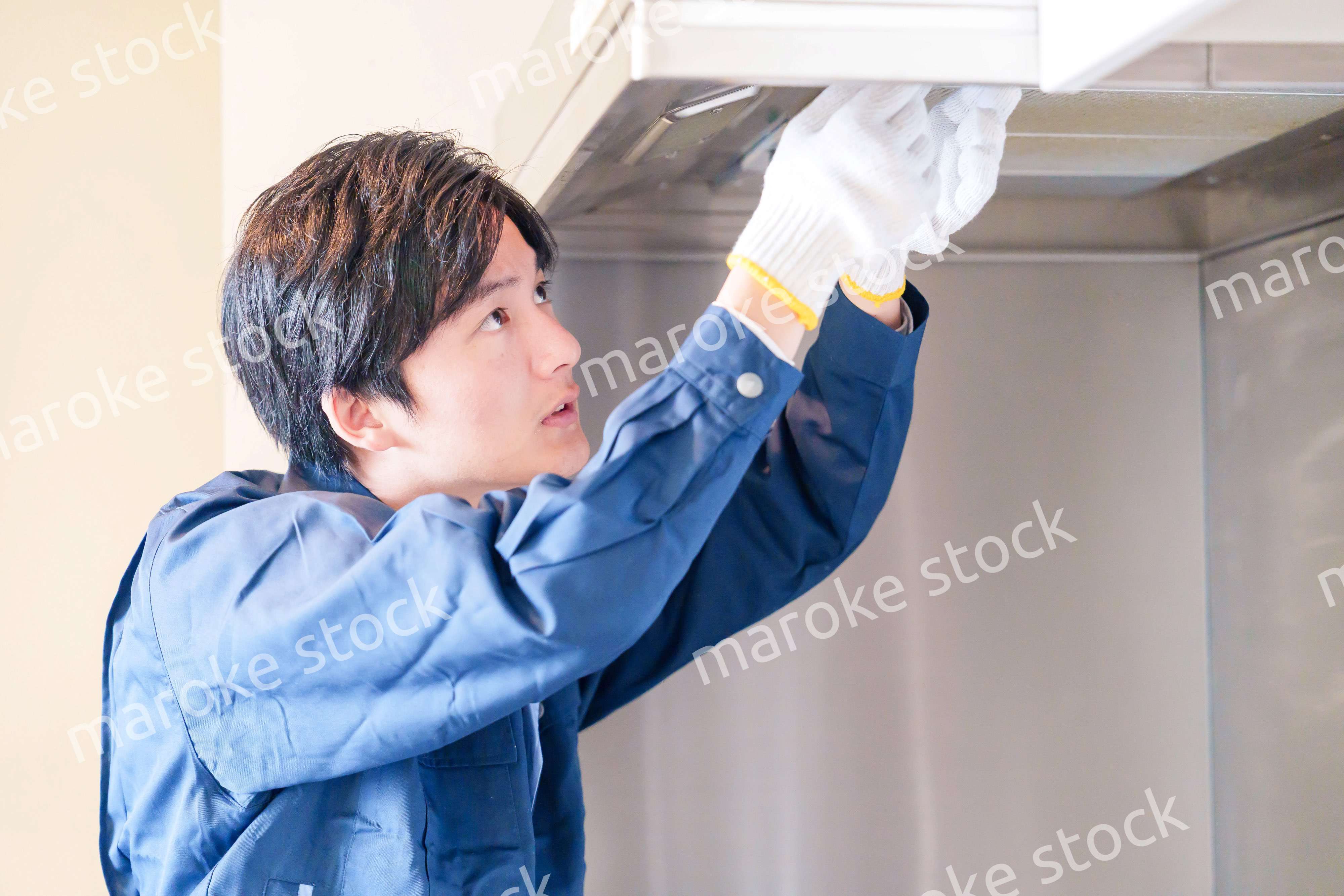 レンジフードのクリーニングをする男性の作業員