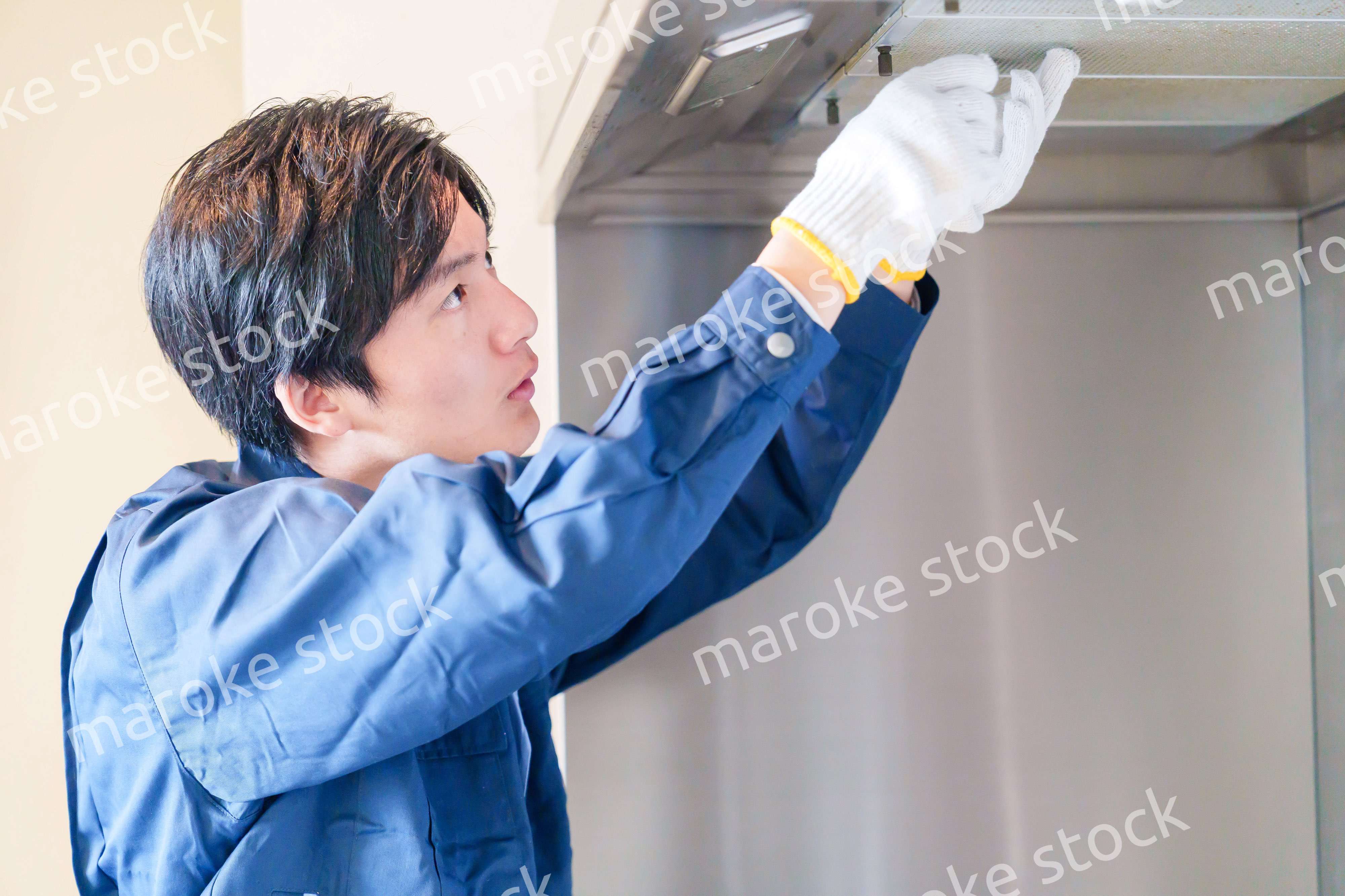 レンジフードのクリーニングをする男性の作業員