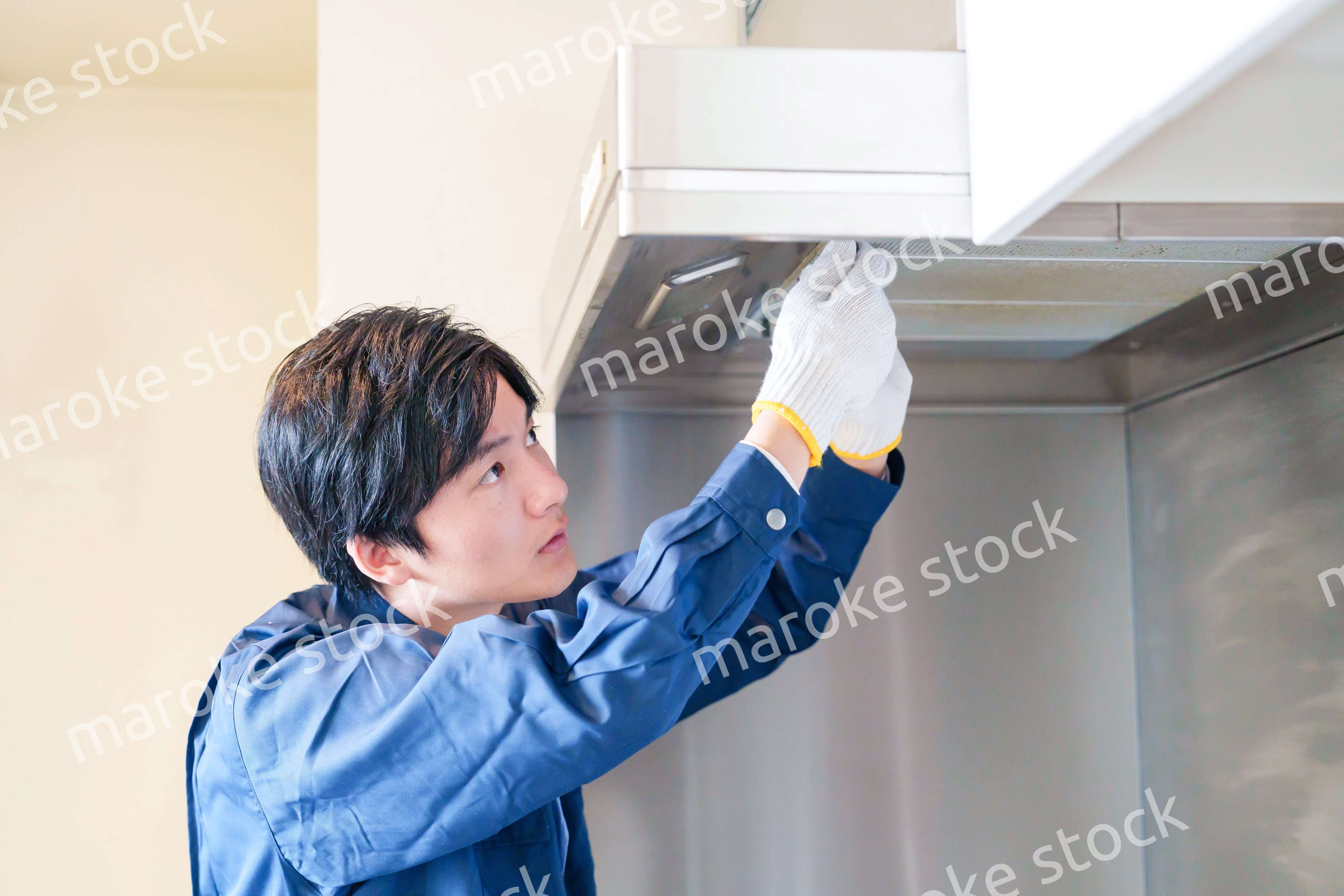 レンジフードのクリーニングをする男性の作業員