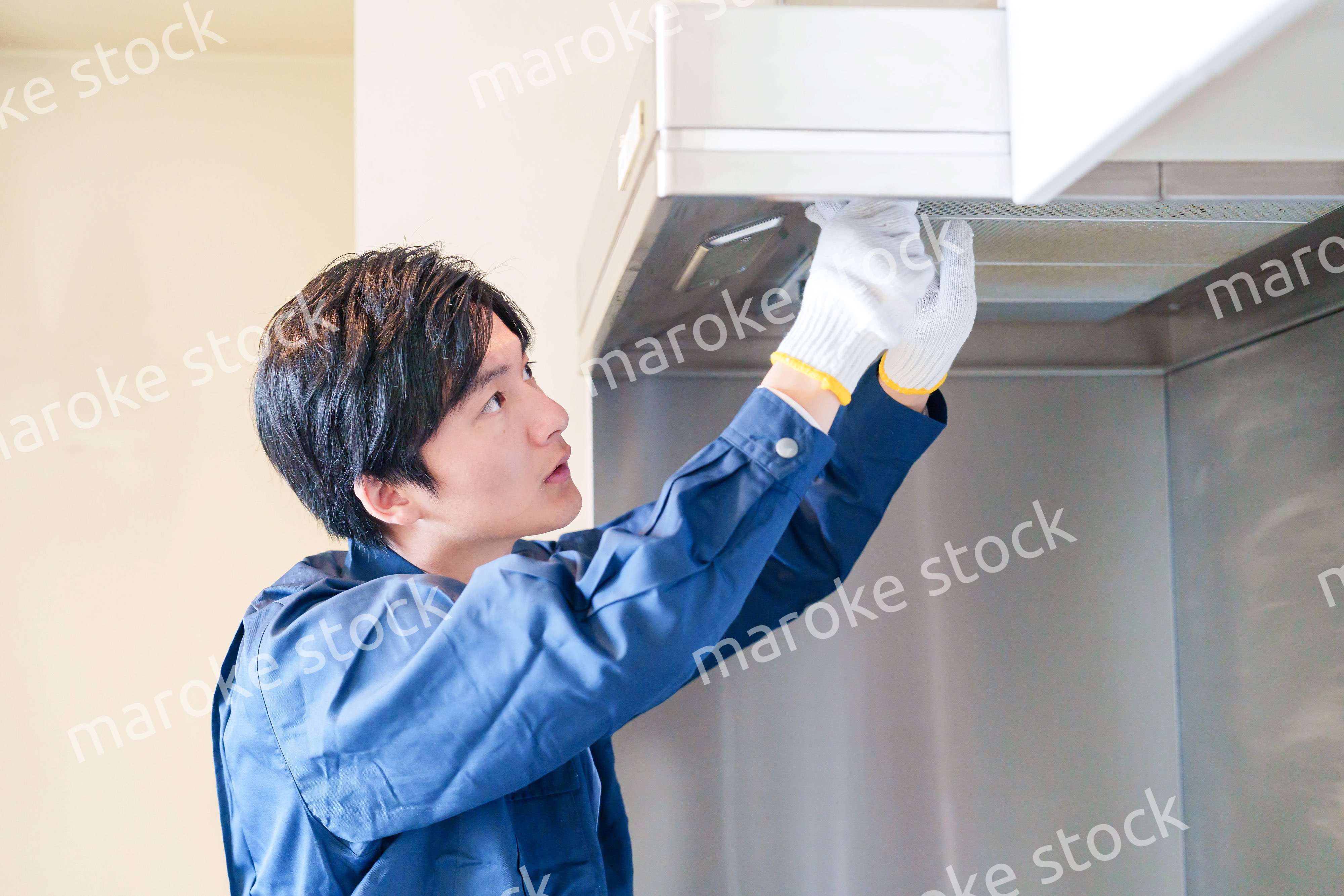 レンジフードのクリーニングをする男性の作業員