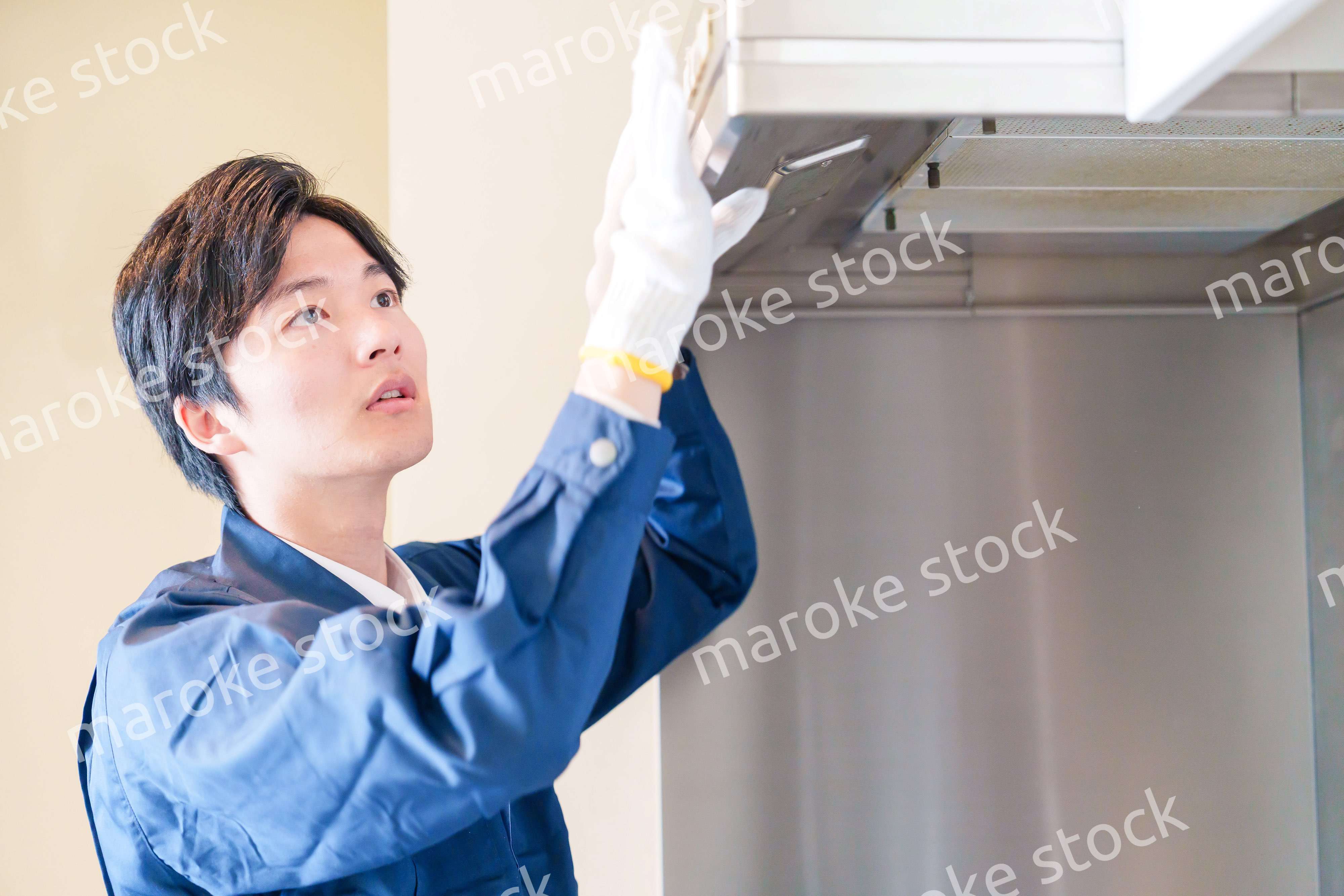 レンジフードのクリーニングをする男性の作業員