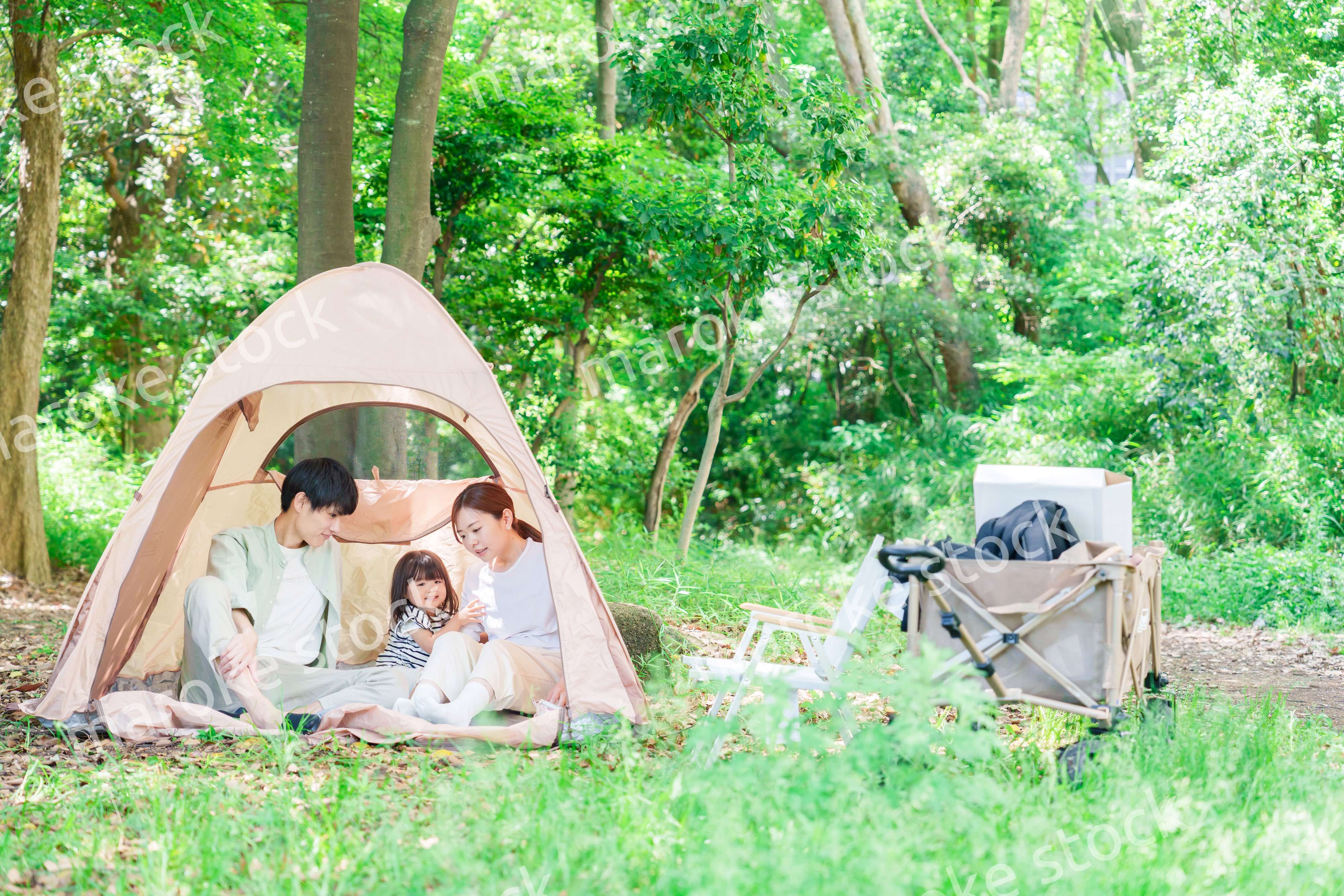 森の中でキャンプを楽しむ子供連れのファミリー