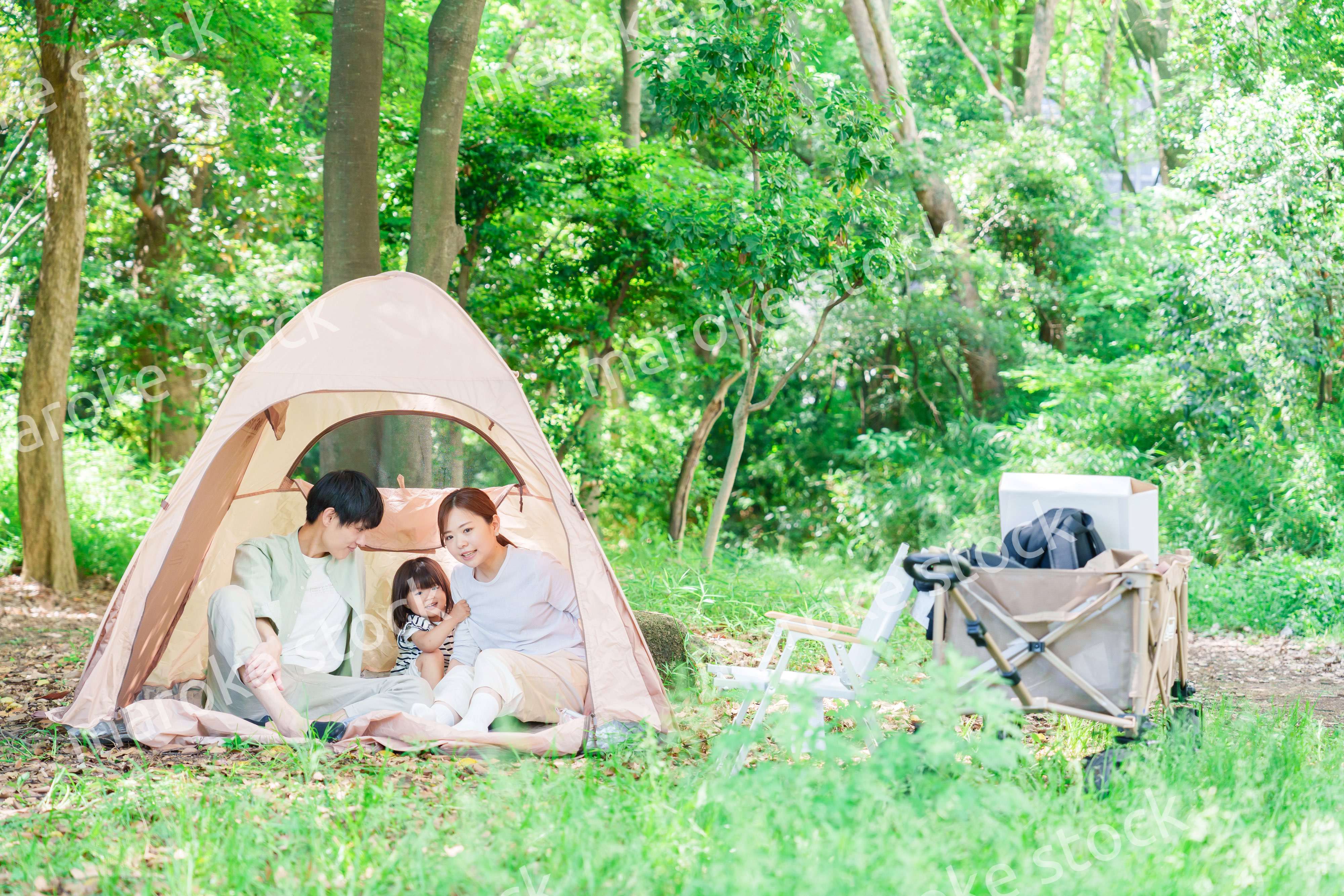 森の中でキャンプを楽しむ子供連れのファミリー