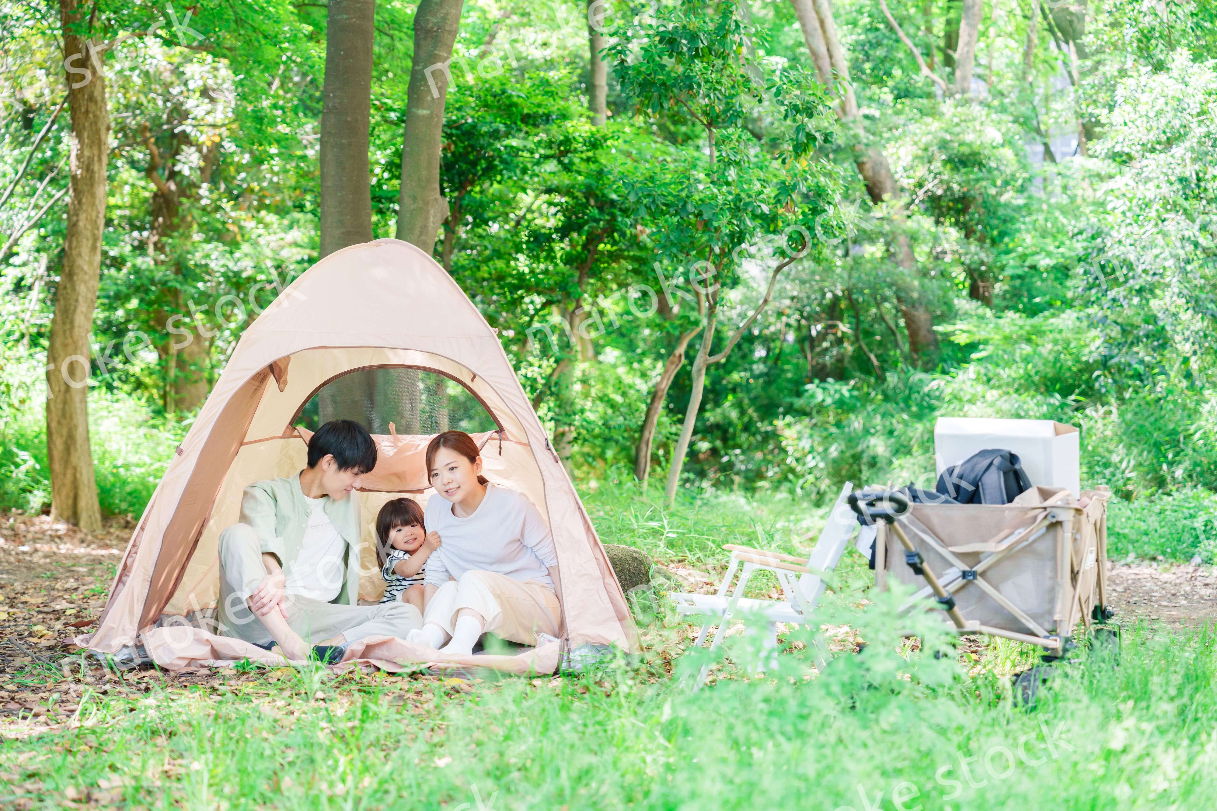 森の中でキャンプを楽しむ子供連れのファミリー