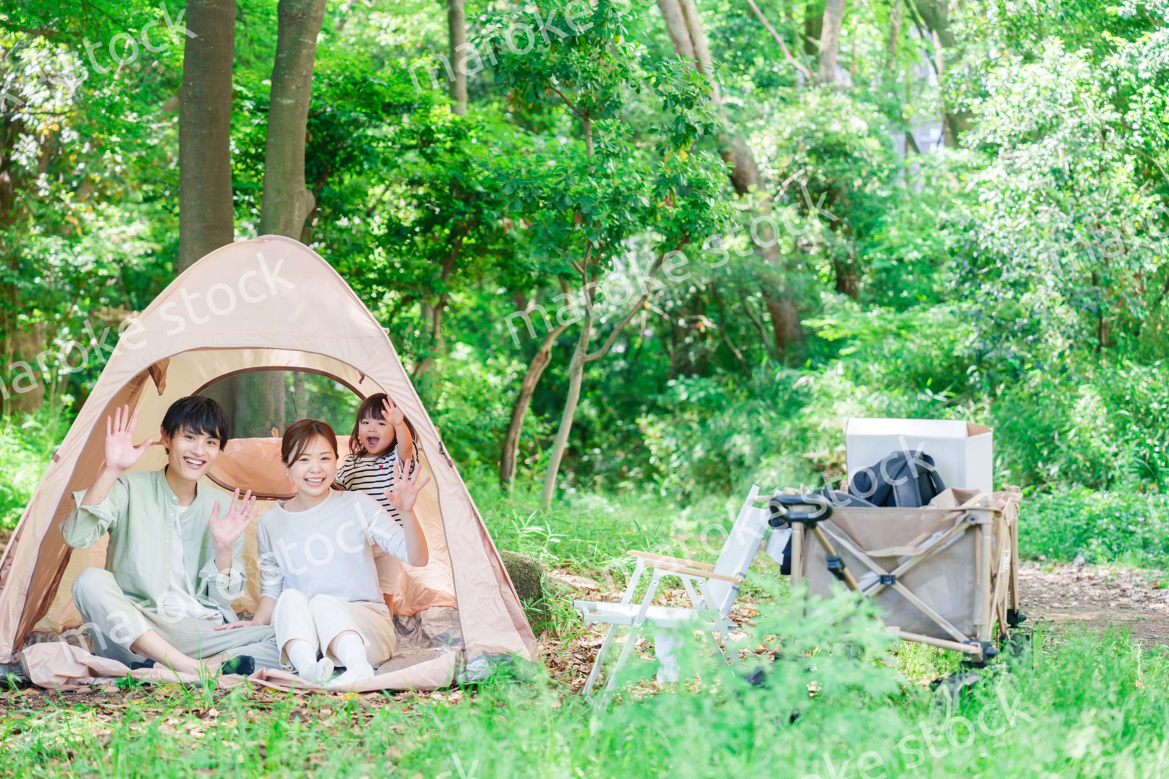 森の中でキャンプを楽しむ子供連れのファミリー