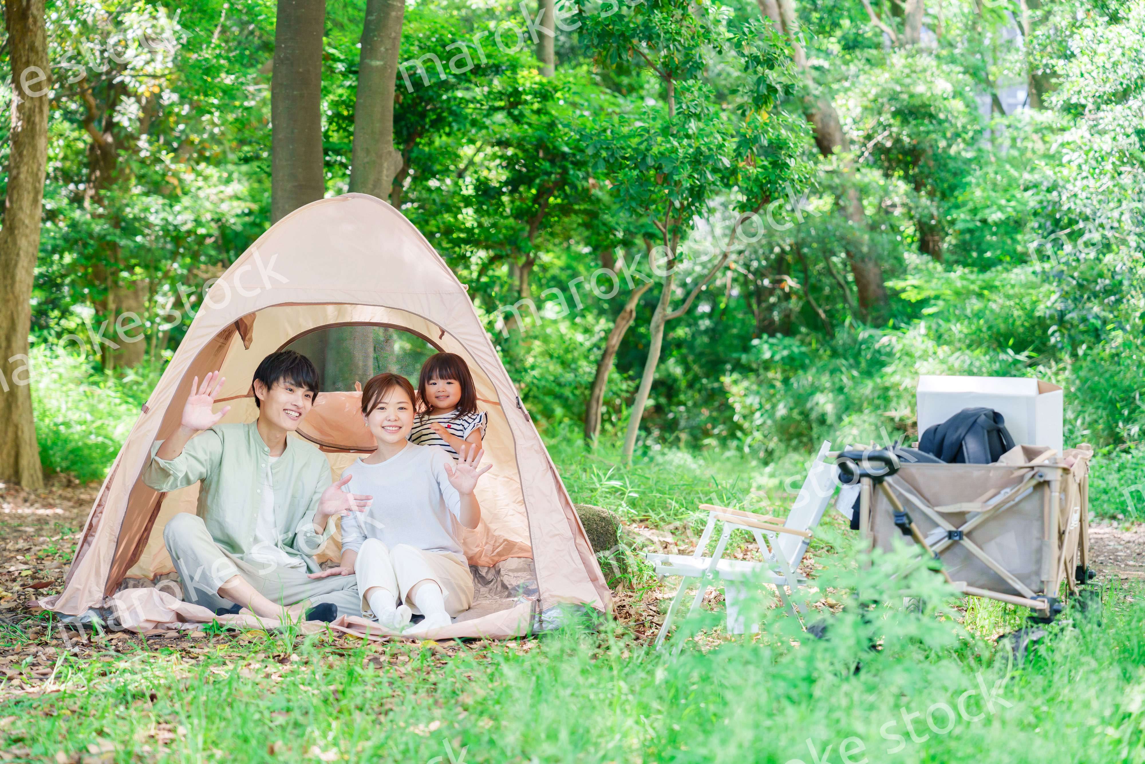 森の中でキャンプを楽しむ子供連れのファミリー