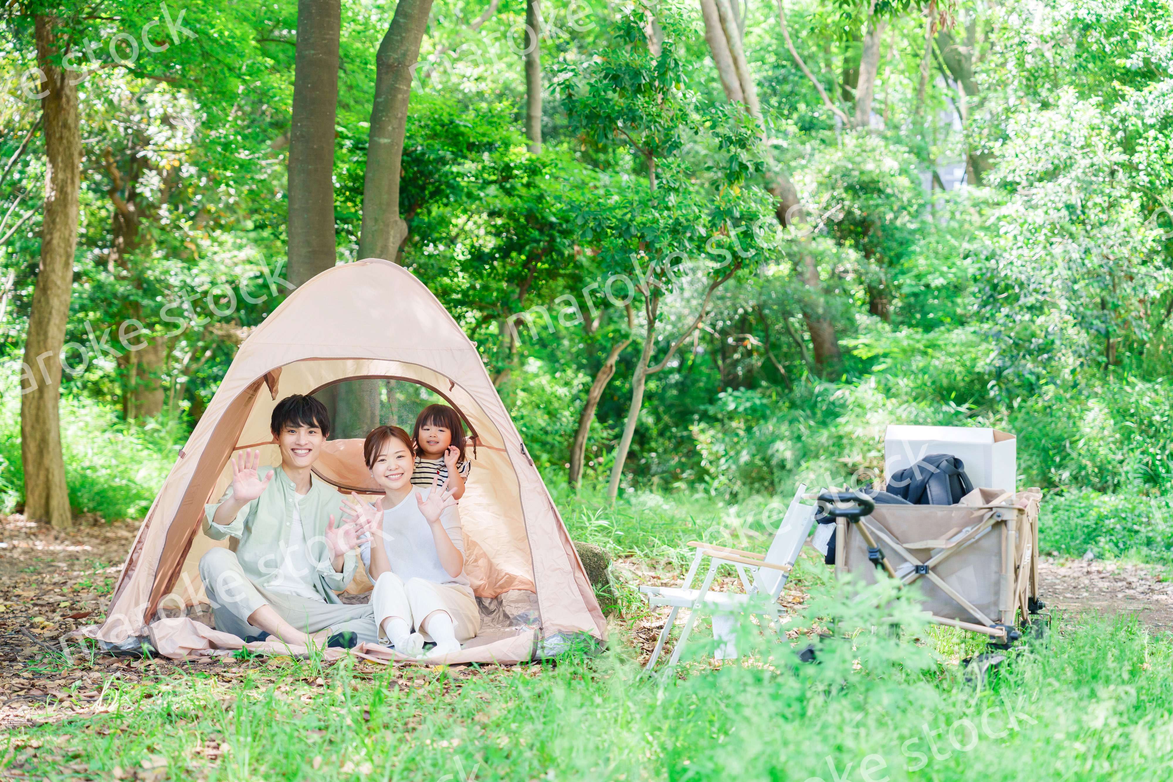 森の中でキャンプを楽しむ子供連れのファミリー
