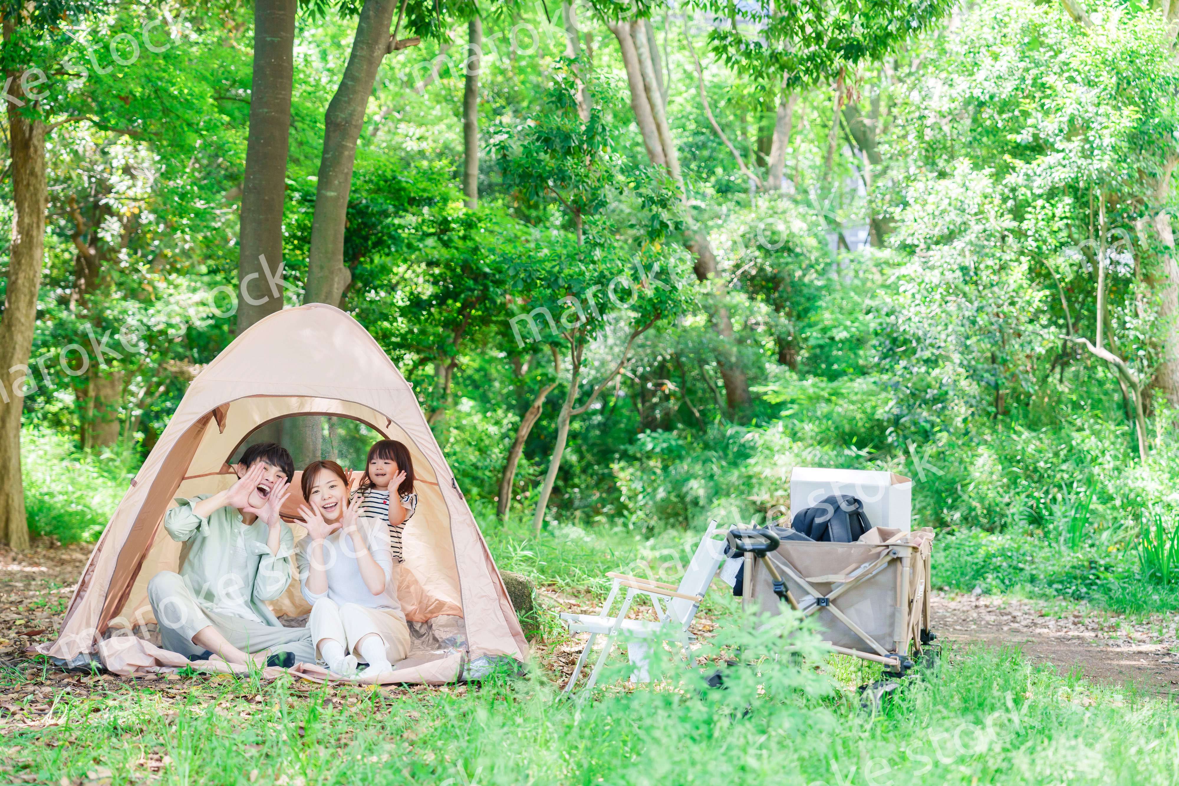 森の中でキャンプを楽しむ子供連れのファミリー