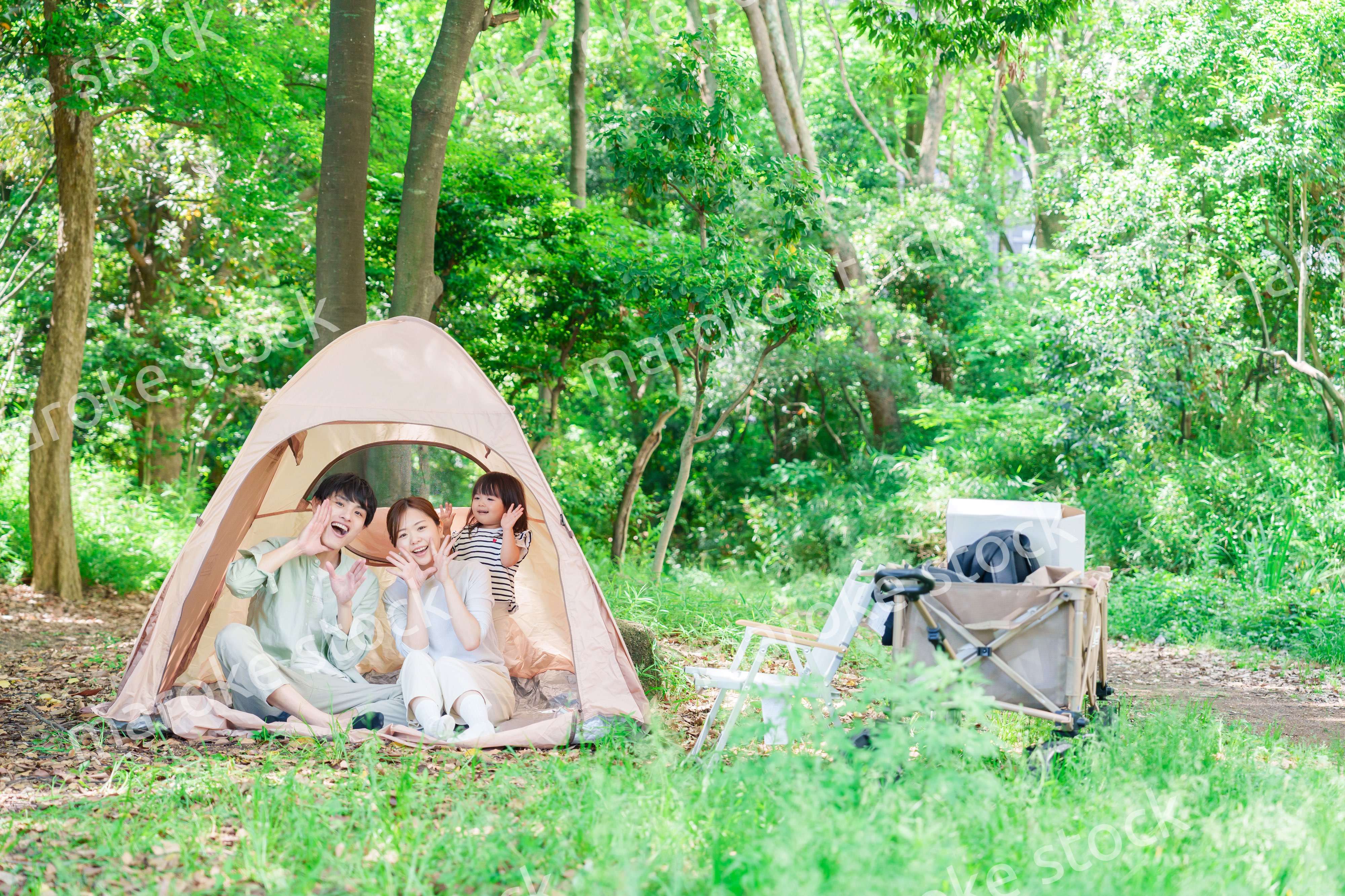 森の中でキャンプを楽しむ子供連れのファミリー