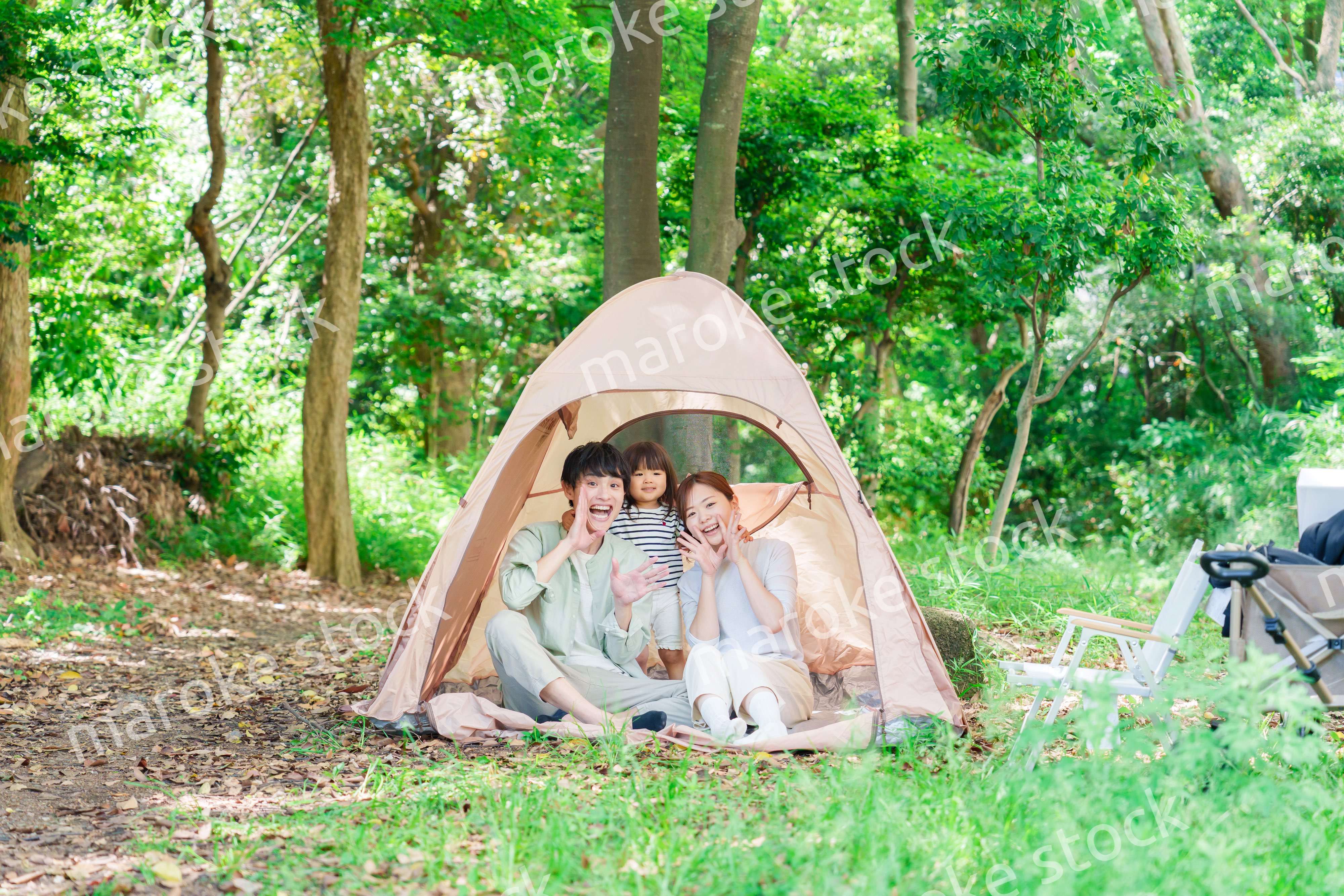 森の中でキャンプを楽しむ子供連れのファミリー
