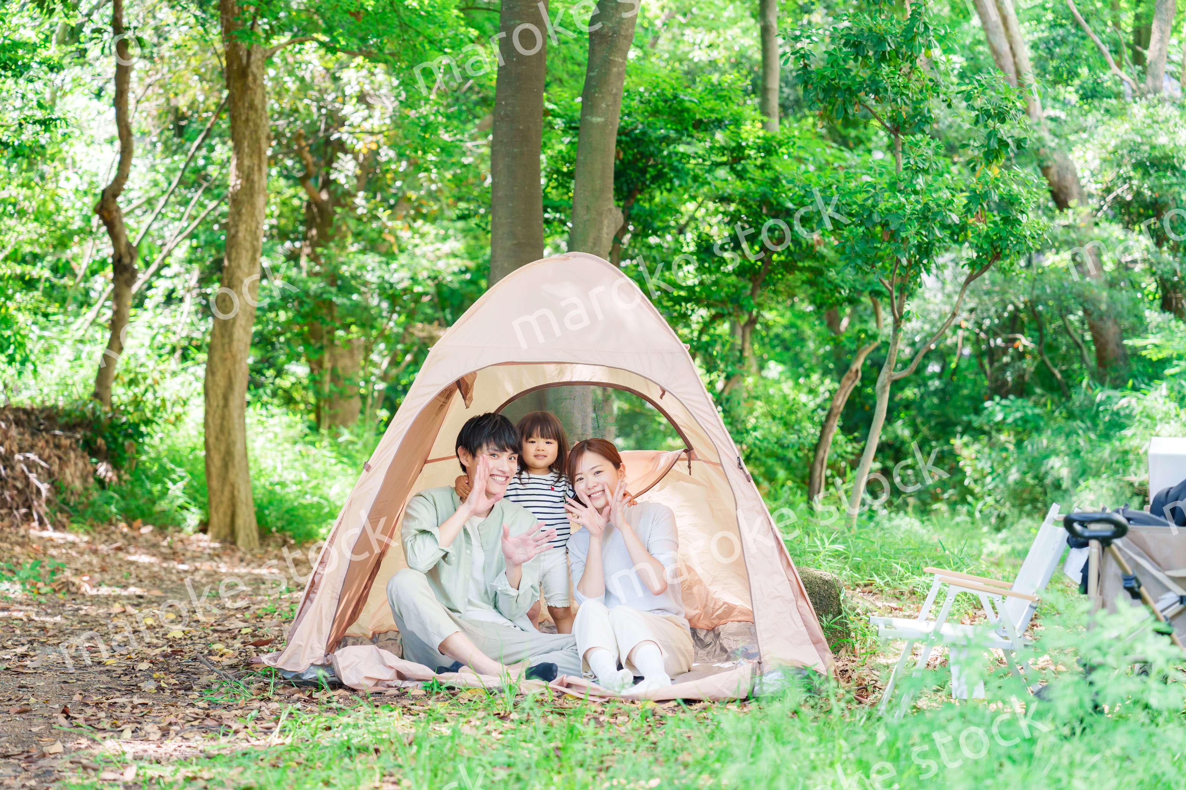 森の中でキャンプを楽しむ子供連れのファミリー