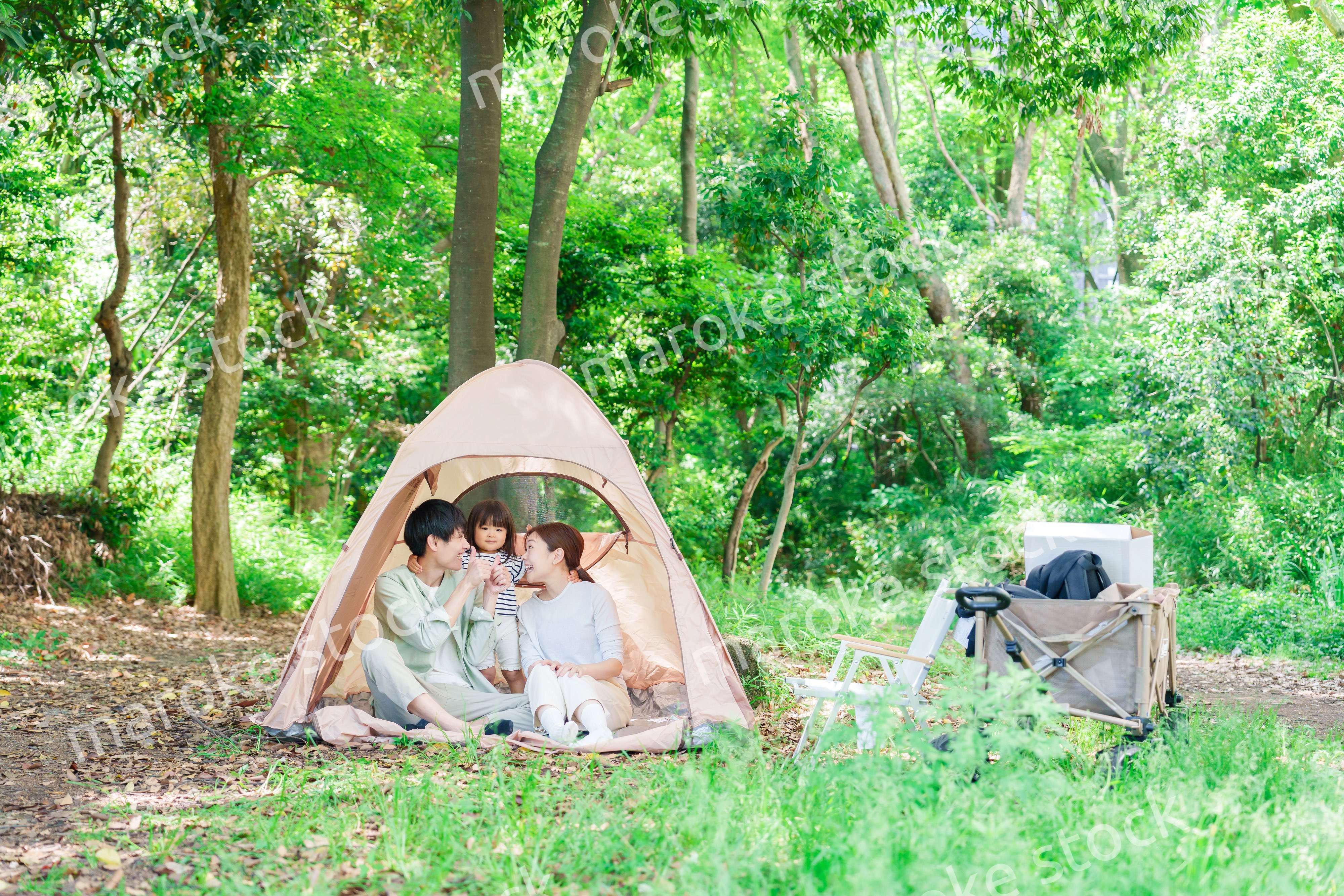 森の中でキャンプを楽しむ子供連れのファミリー