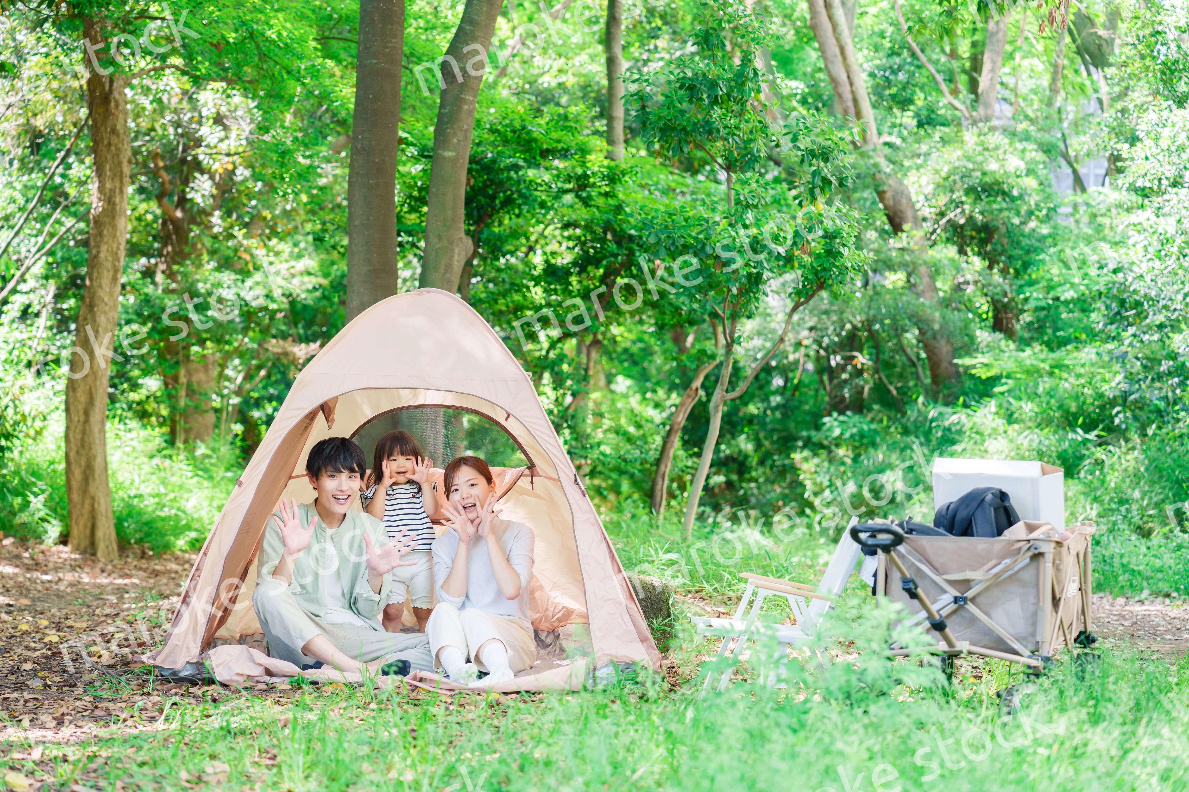 森の中でキャンプを楽しむ子供連れのファミリー