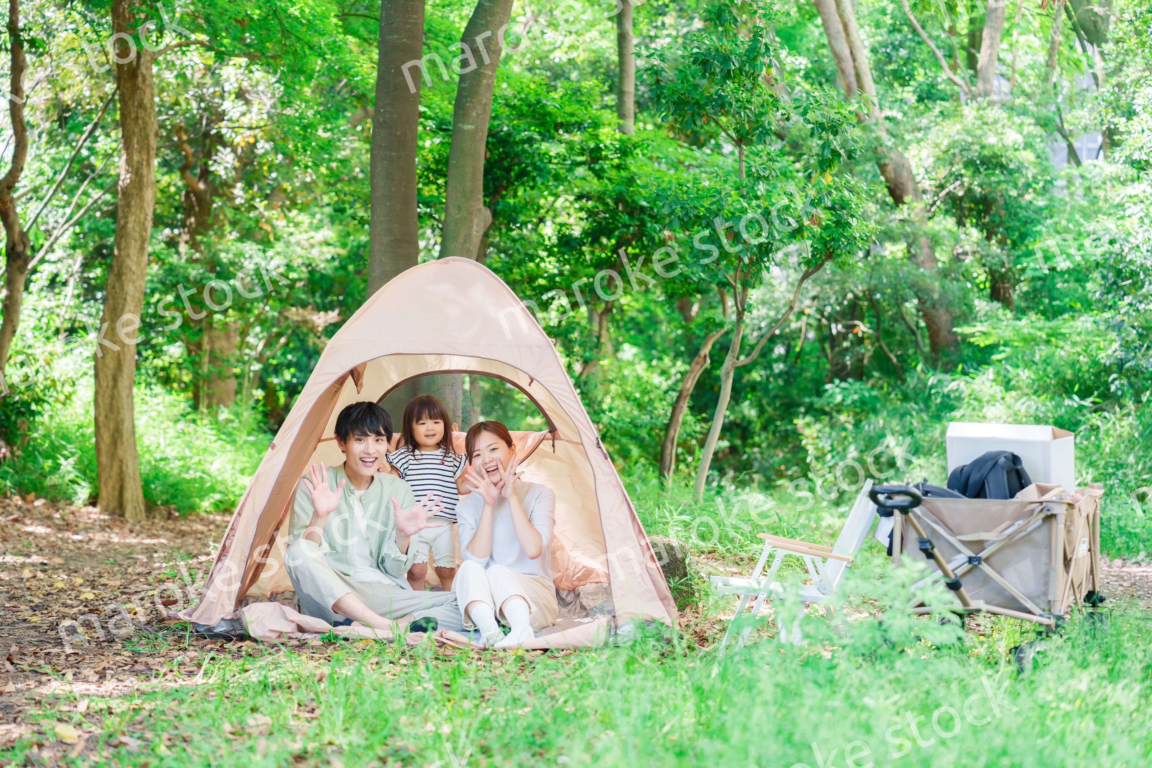 森の中でキャンプを楽しむ子供連れのファミリー