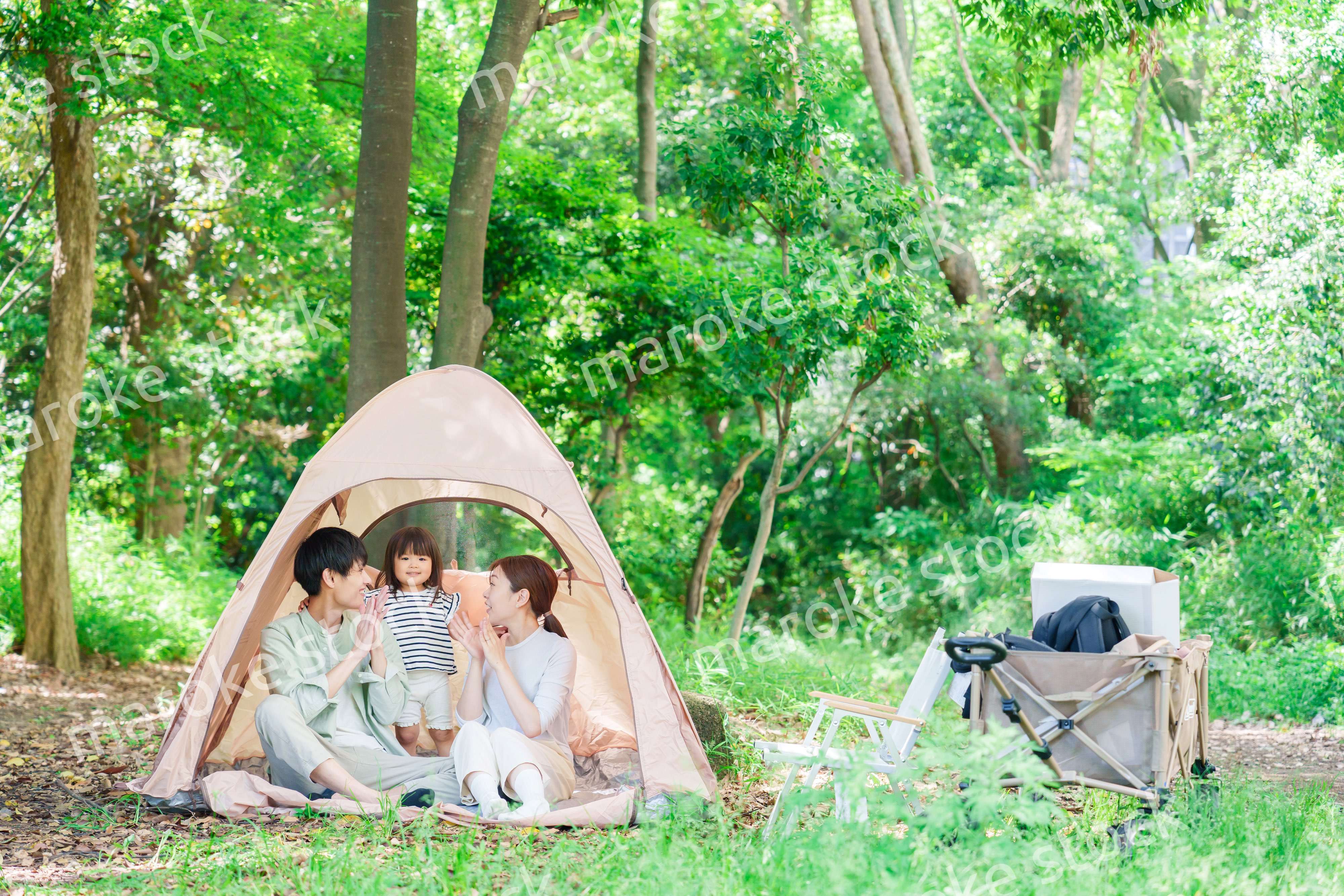 森の中でキャンプを楽しむ子供連れのファミリー