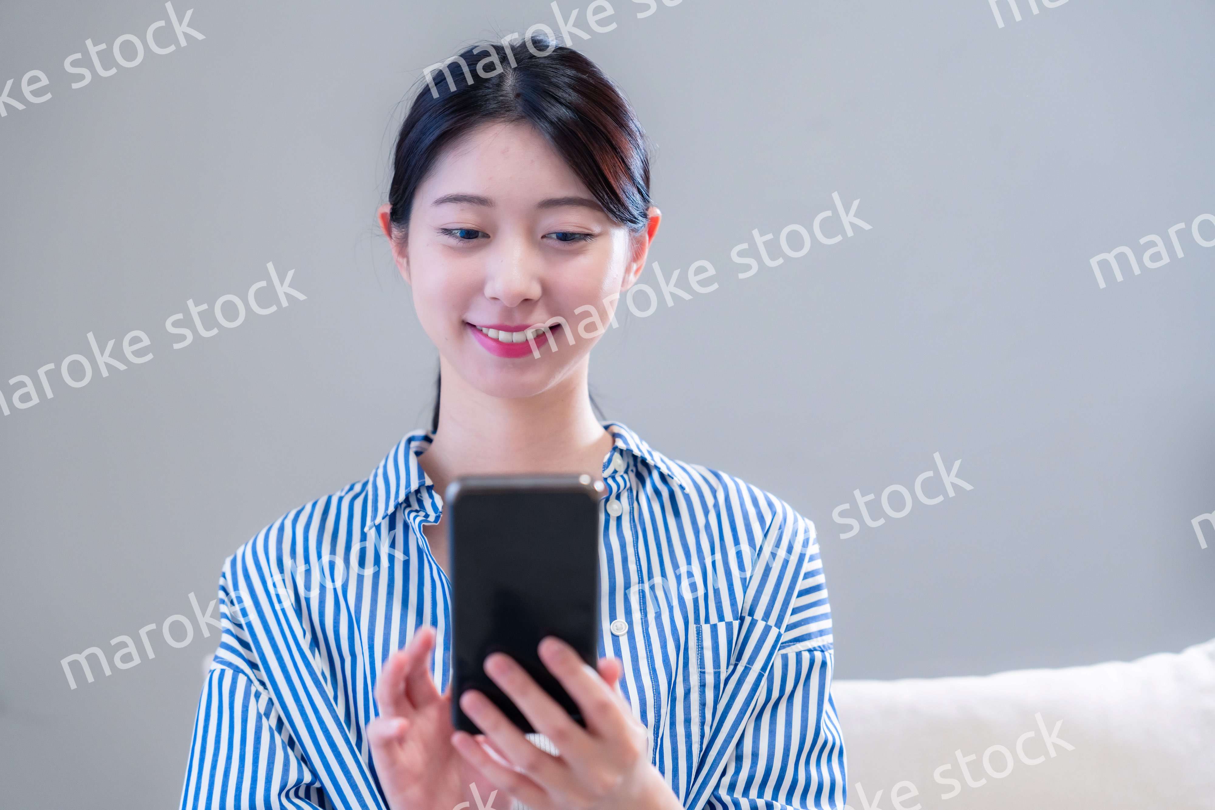 笑顔でスマホアプリを使う若い女性