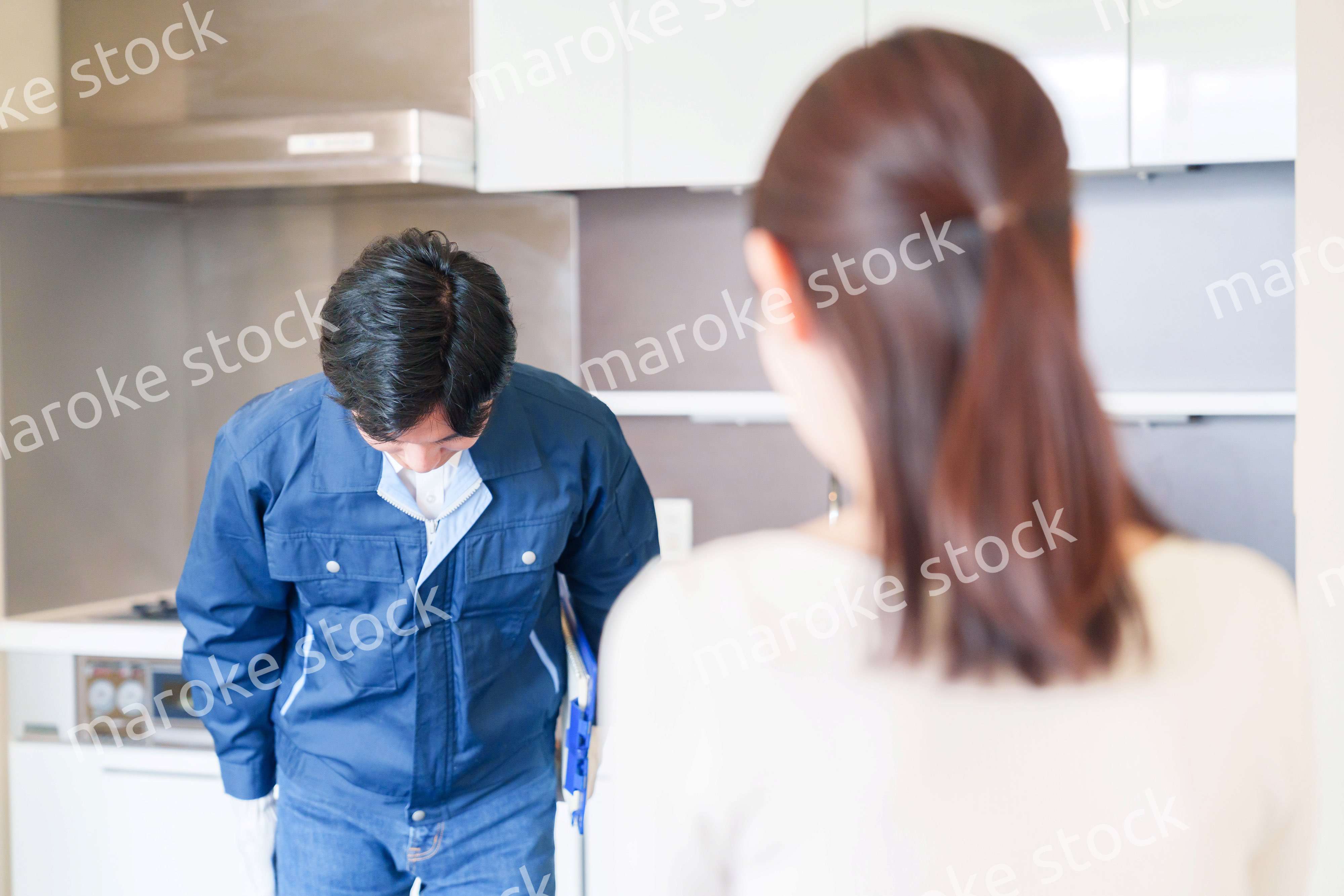 お客様に頭を下げてお詫びをする作業員の男性