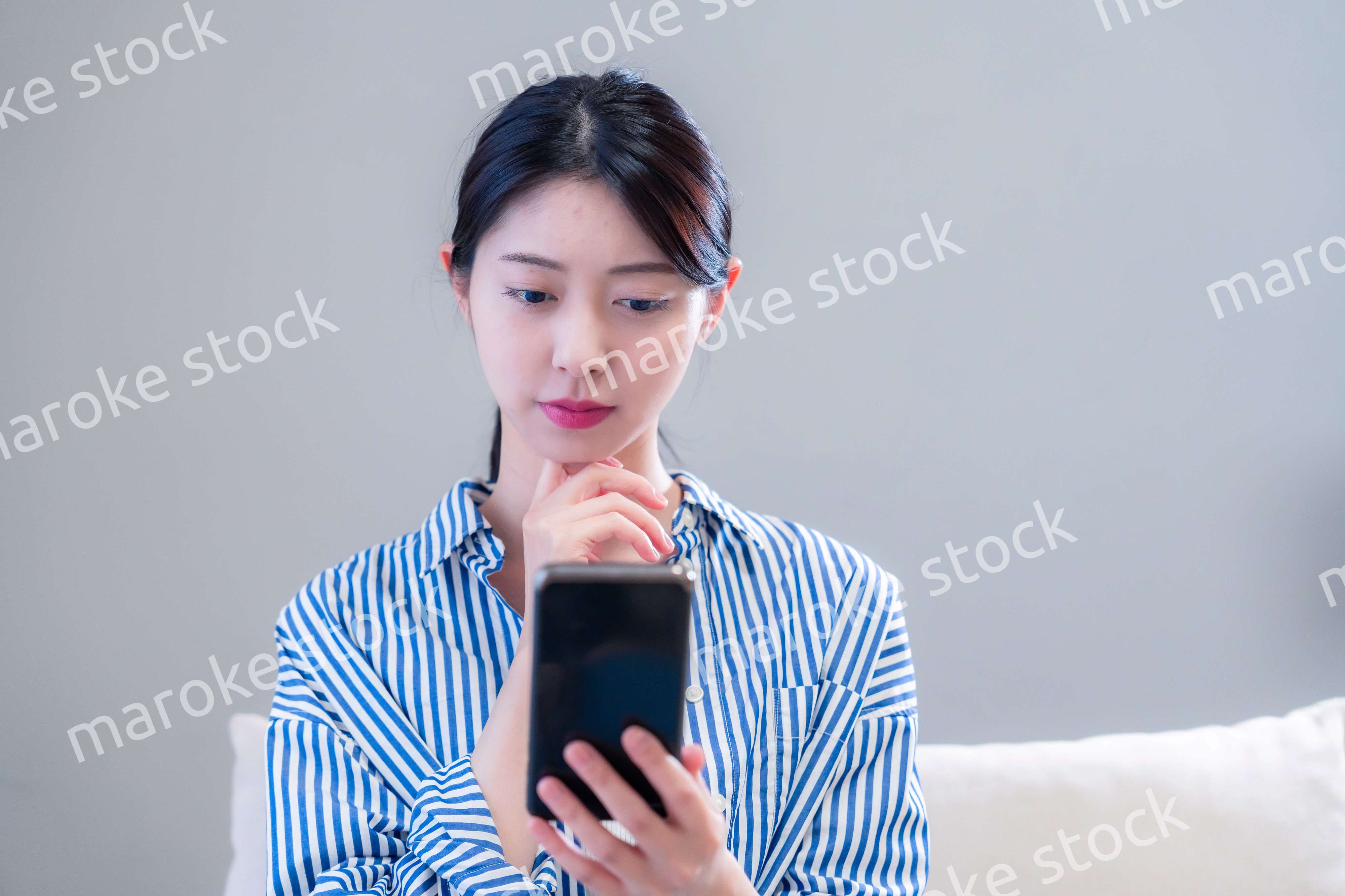 笑顔でスマホアプリを使う若い女性