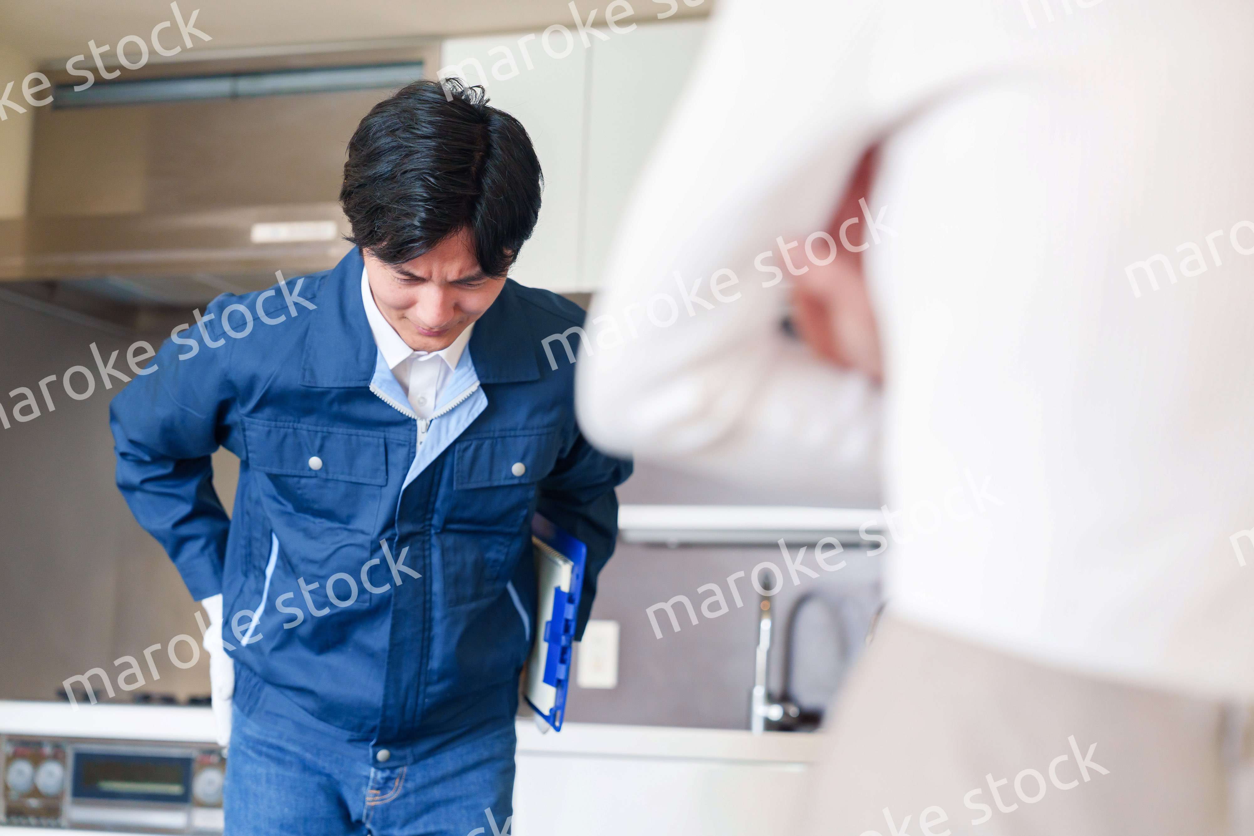 お客様に頭を下げてお詫びをする作業員の男性