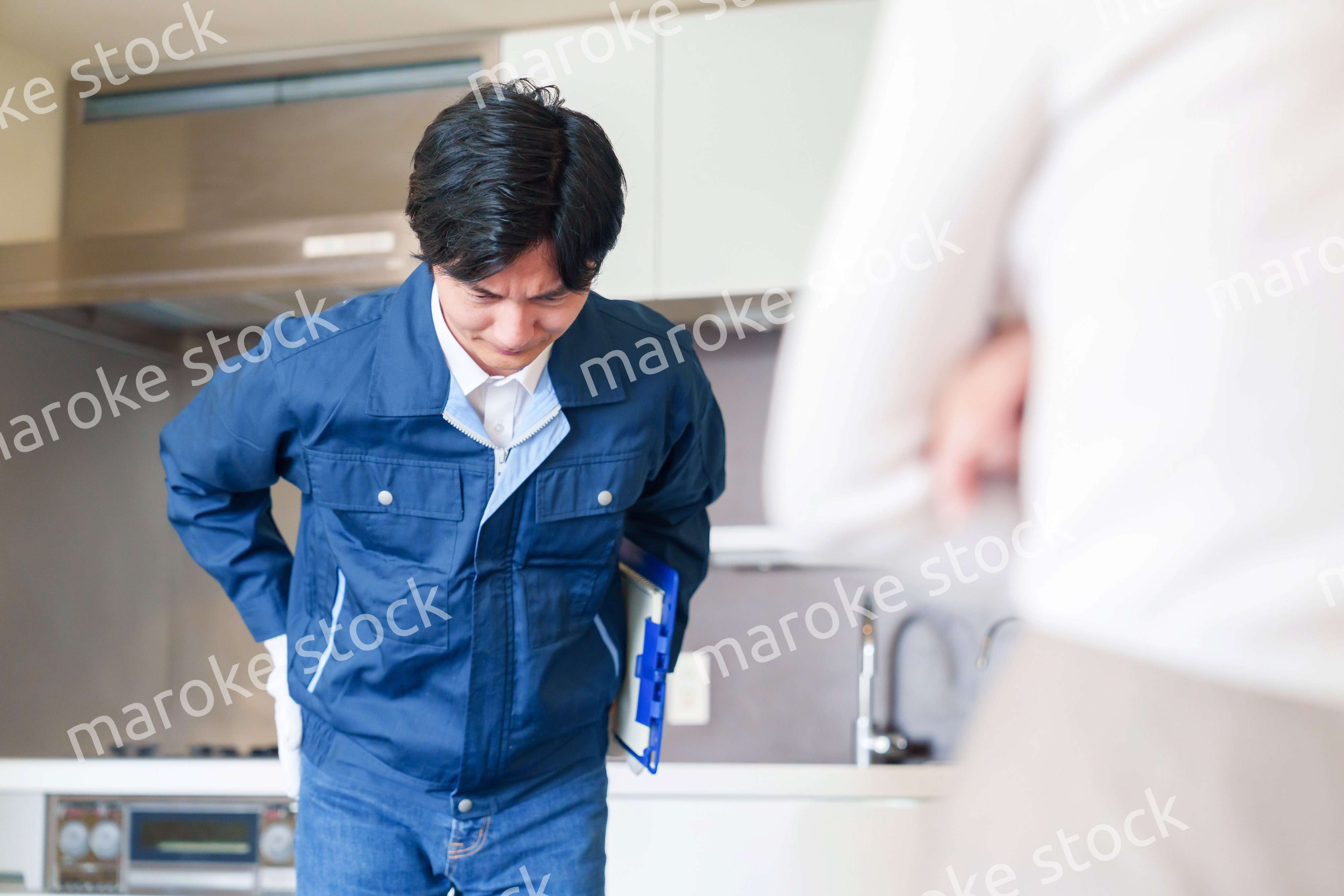 お客様に頭を下げてお詫びをする作業員の男性