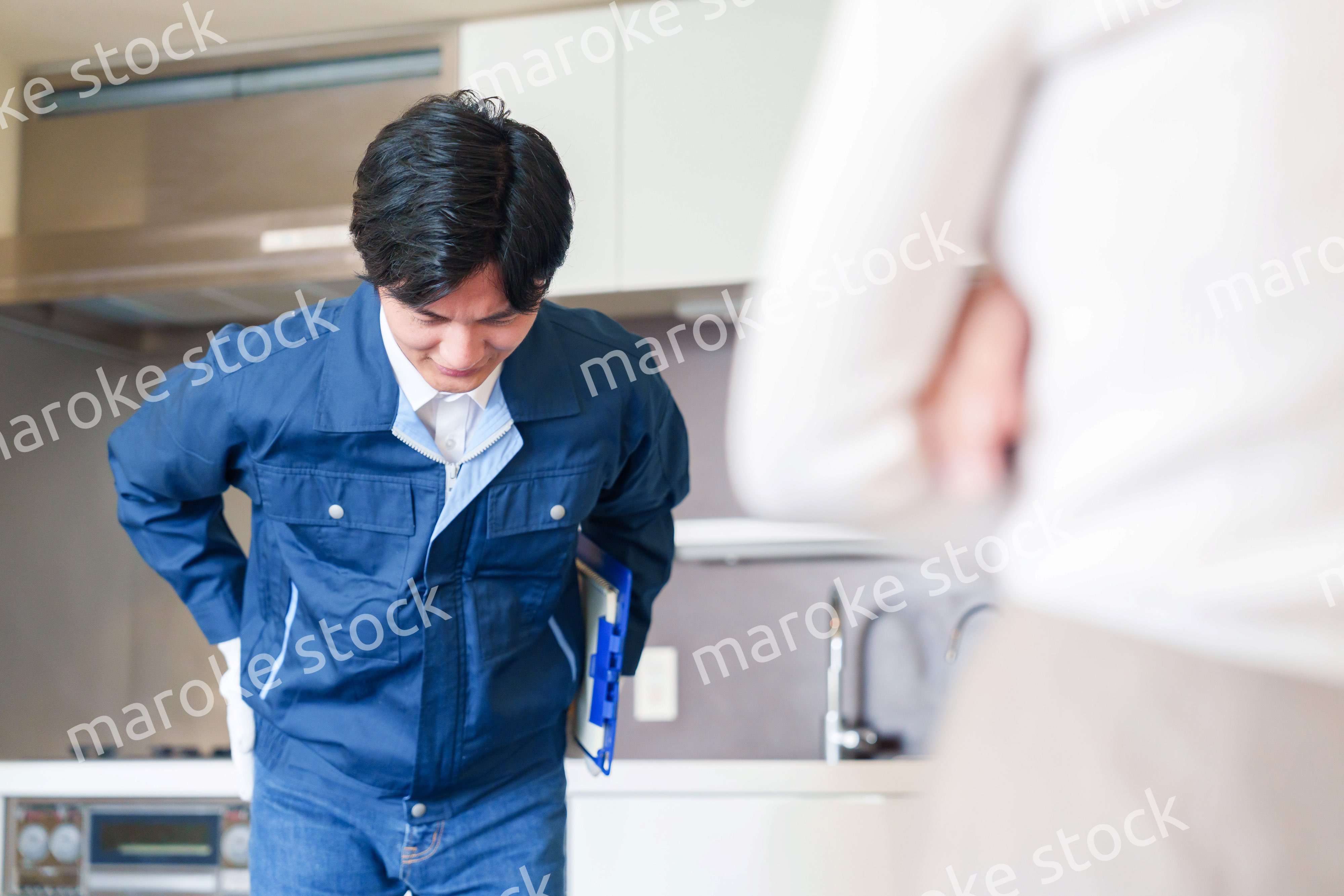 お客様に頭を下げてお詫びをする作業員の男性