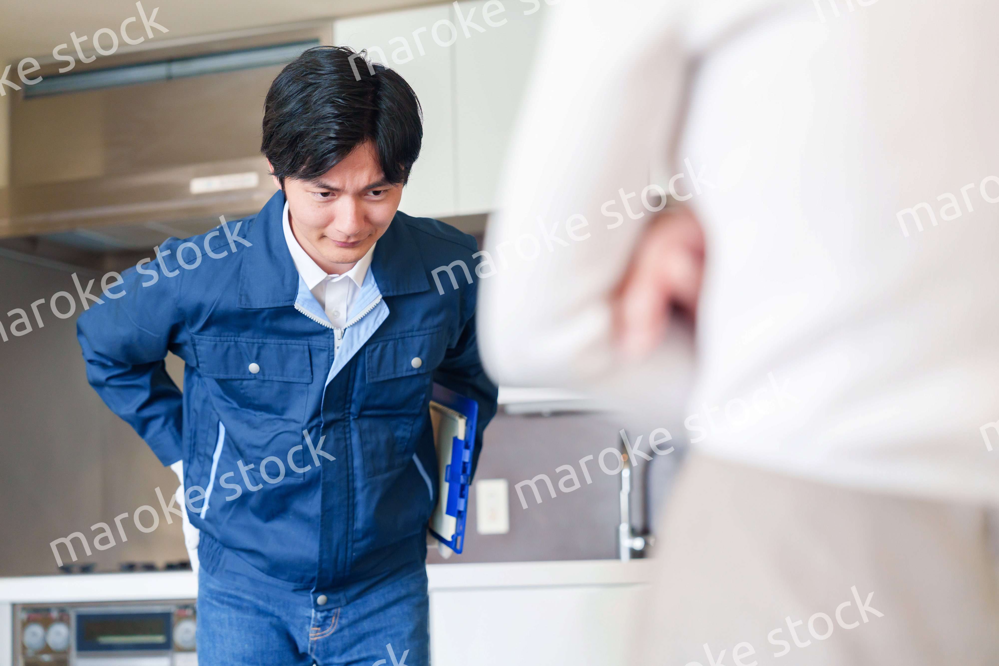 お客様に頭を下げてお詫びをする作業員の男性