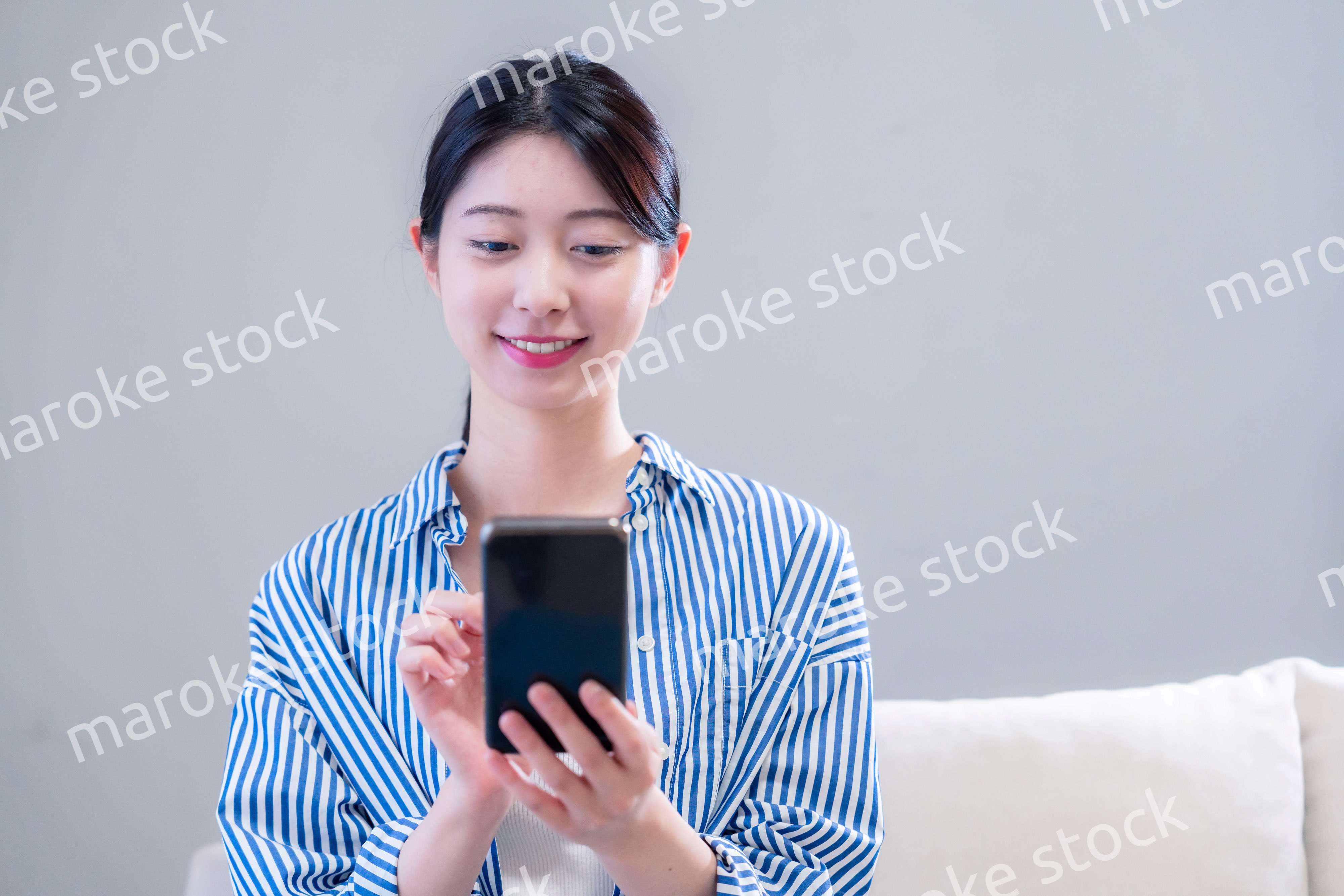 笑顔でスマホアプリを使う若い女性