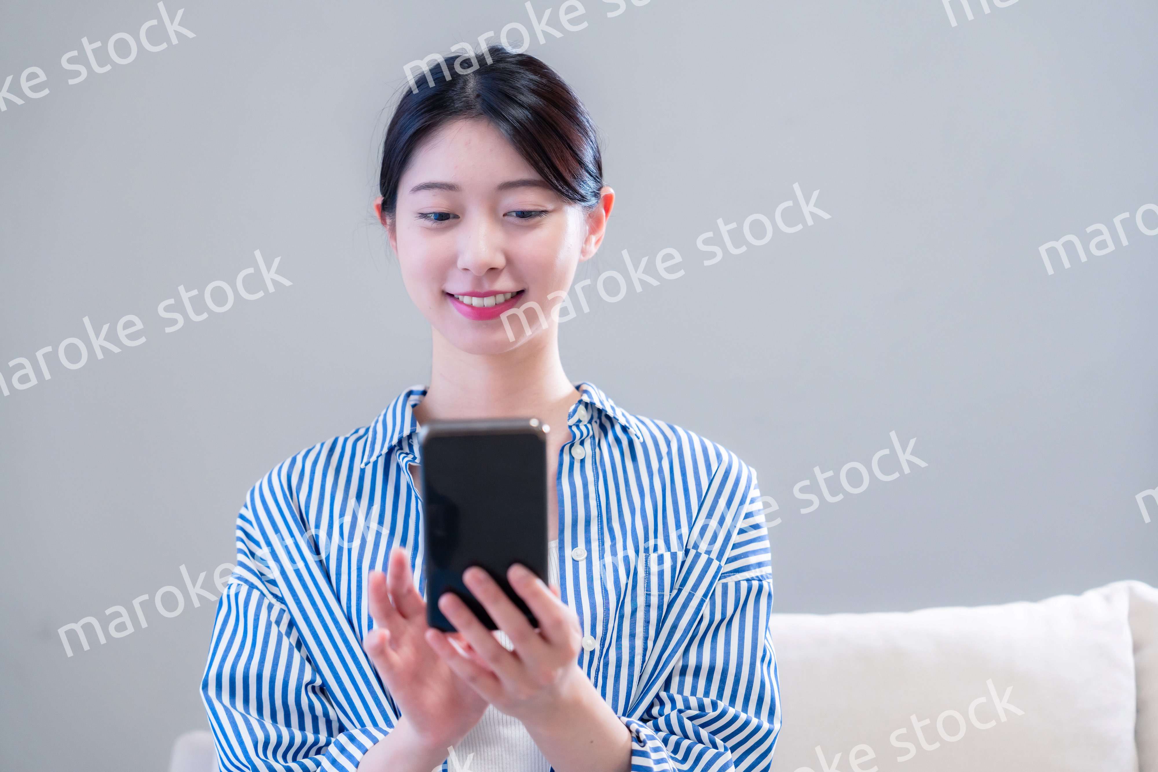 笑顔でスマホアプリを使う若い女性