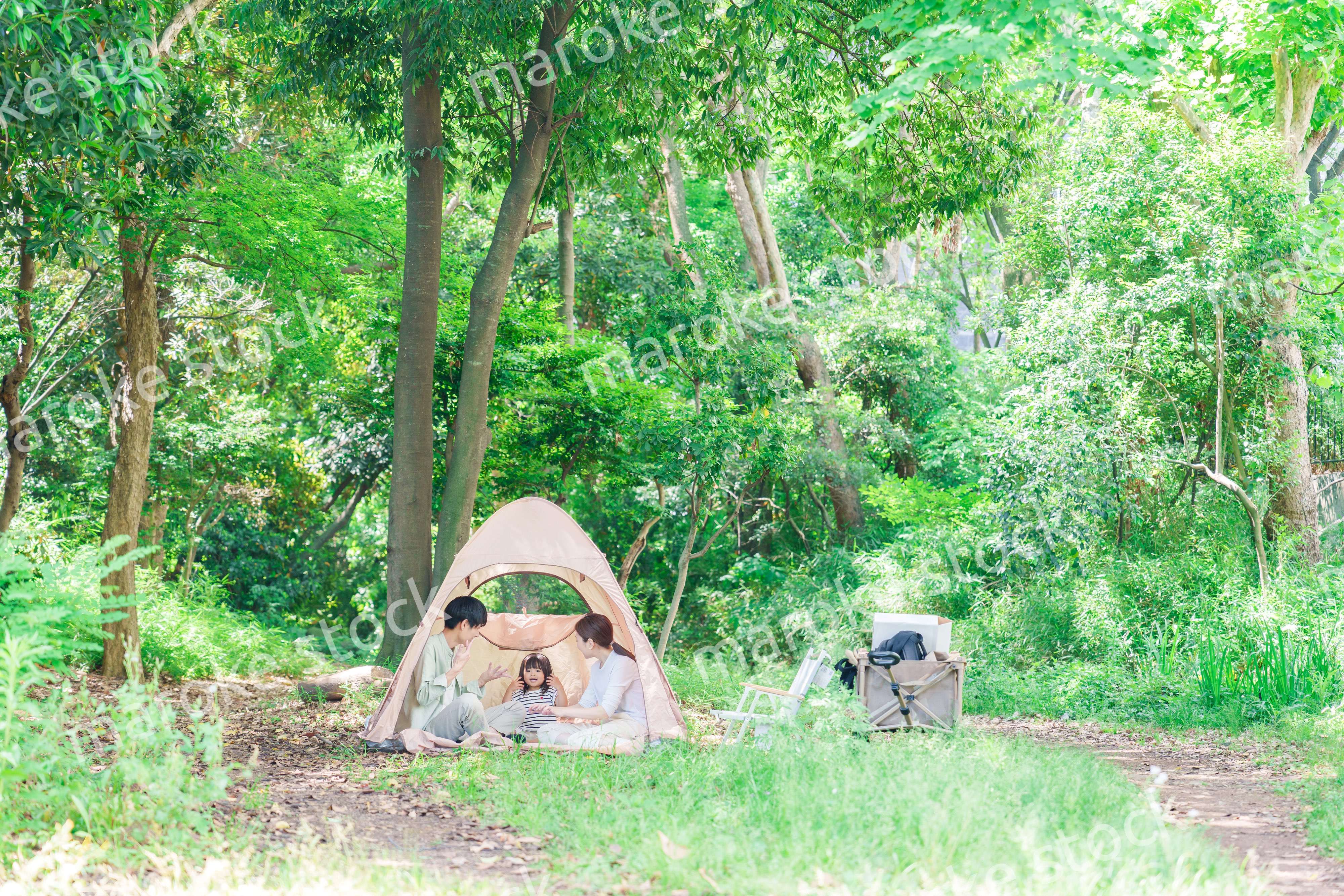 森の中でキャンプを楽しむ子供連れのファミリー