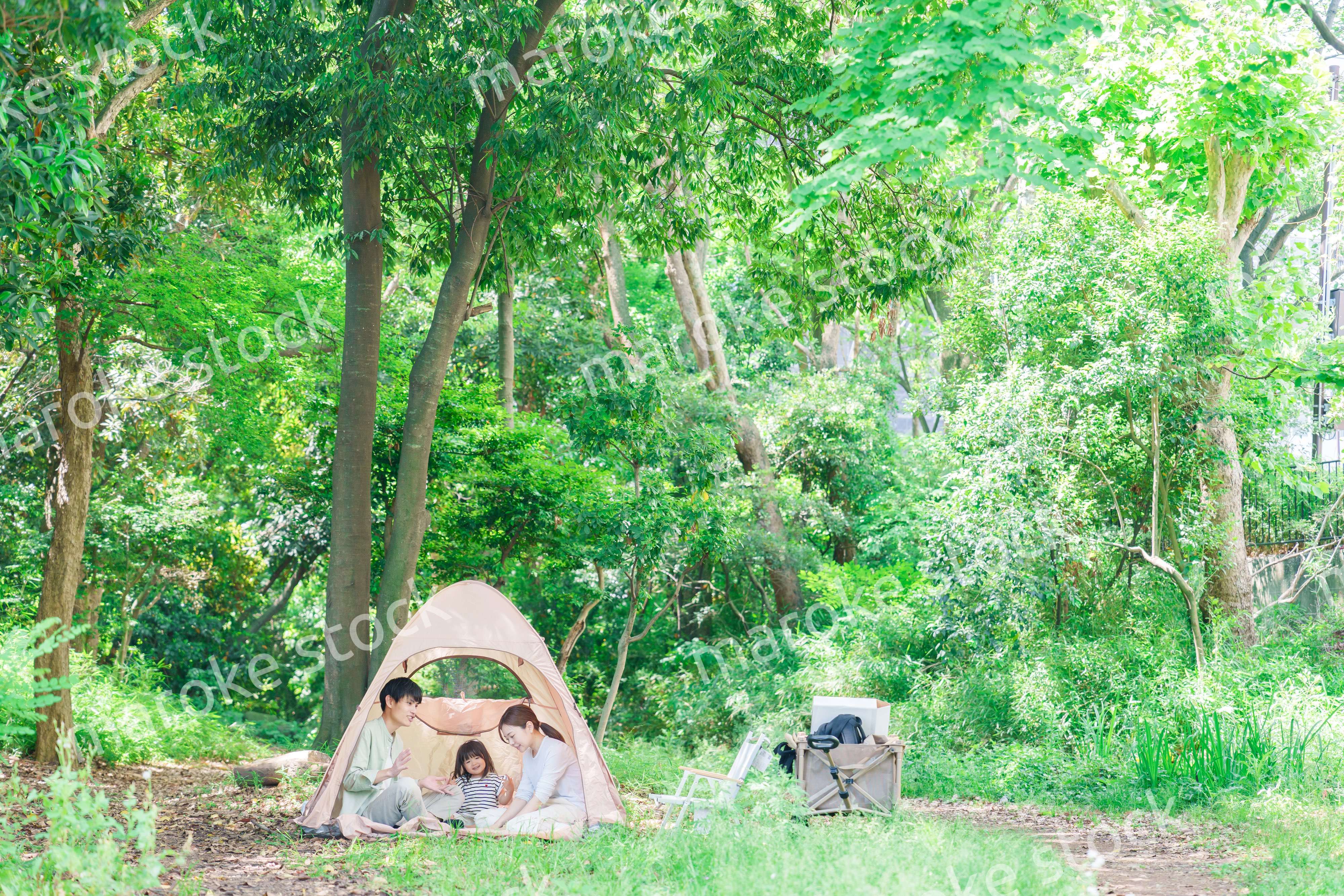 森の中でキャンプを楽しむ子供連れのファミリー