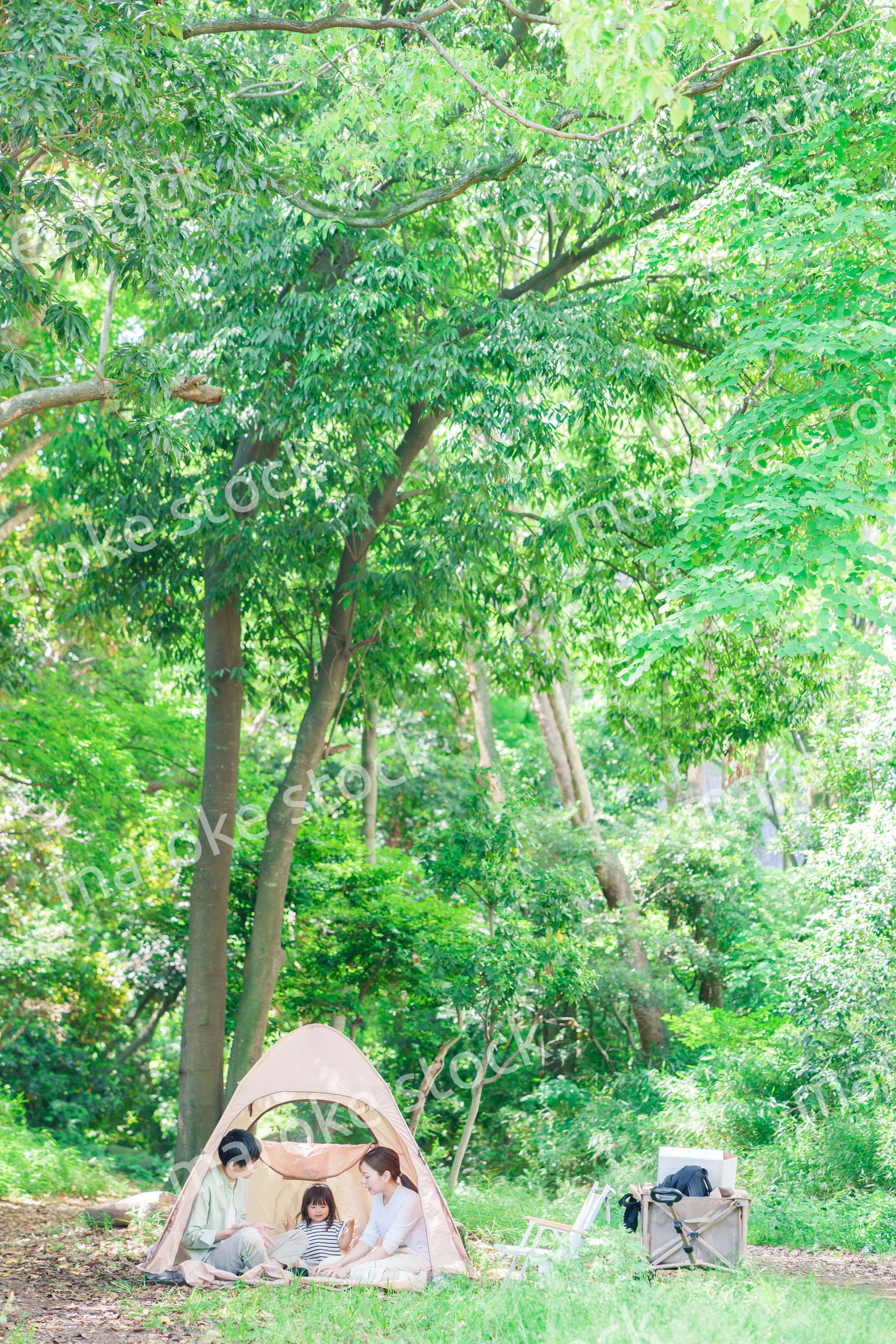 森の中でキャンプを楽しむ子供連れのファミリー