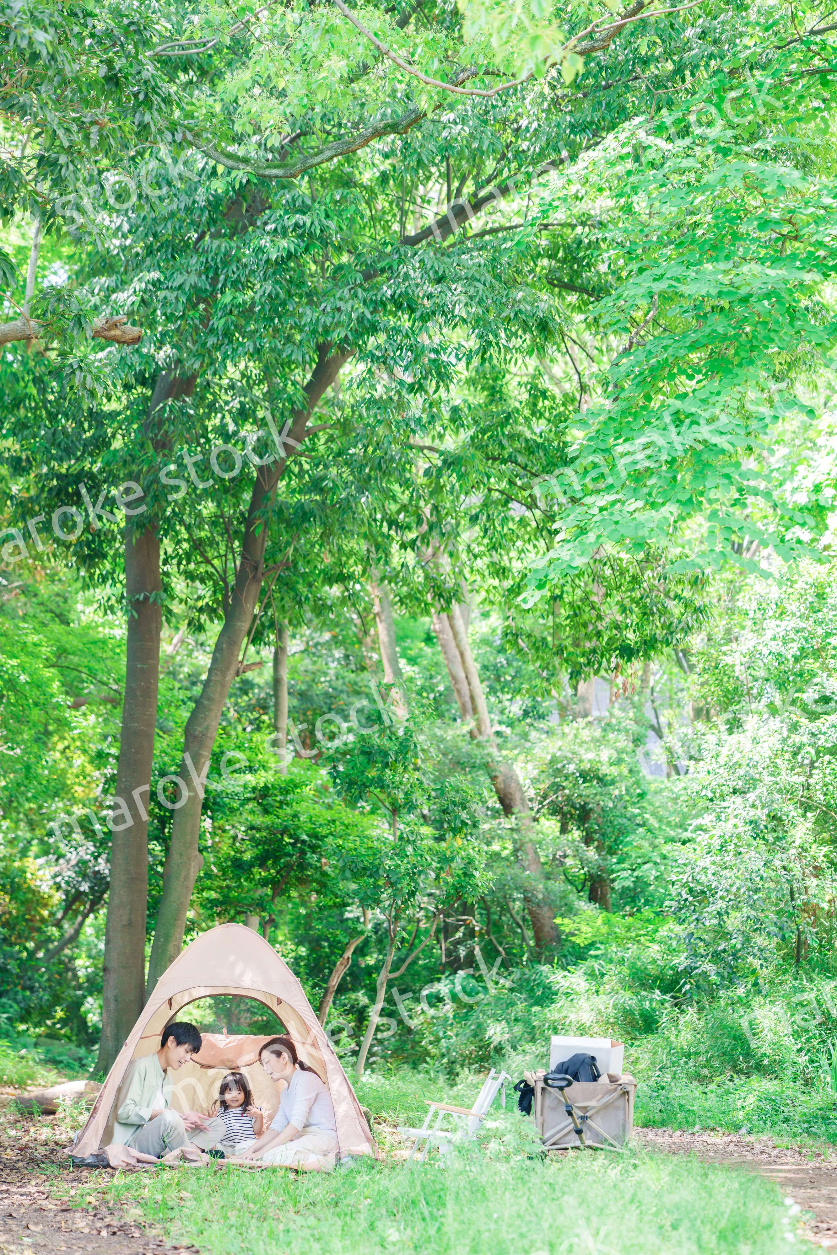 森の中でキャンプを楽しむ子供連れのファミリー