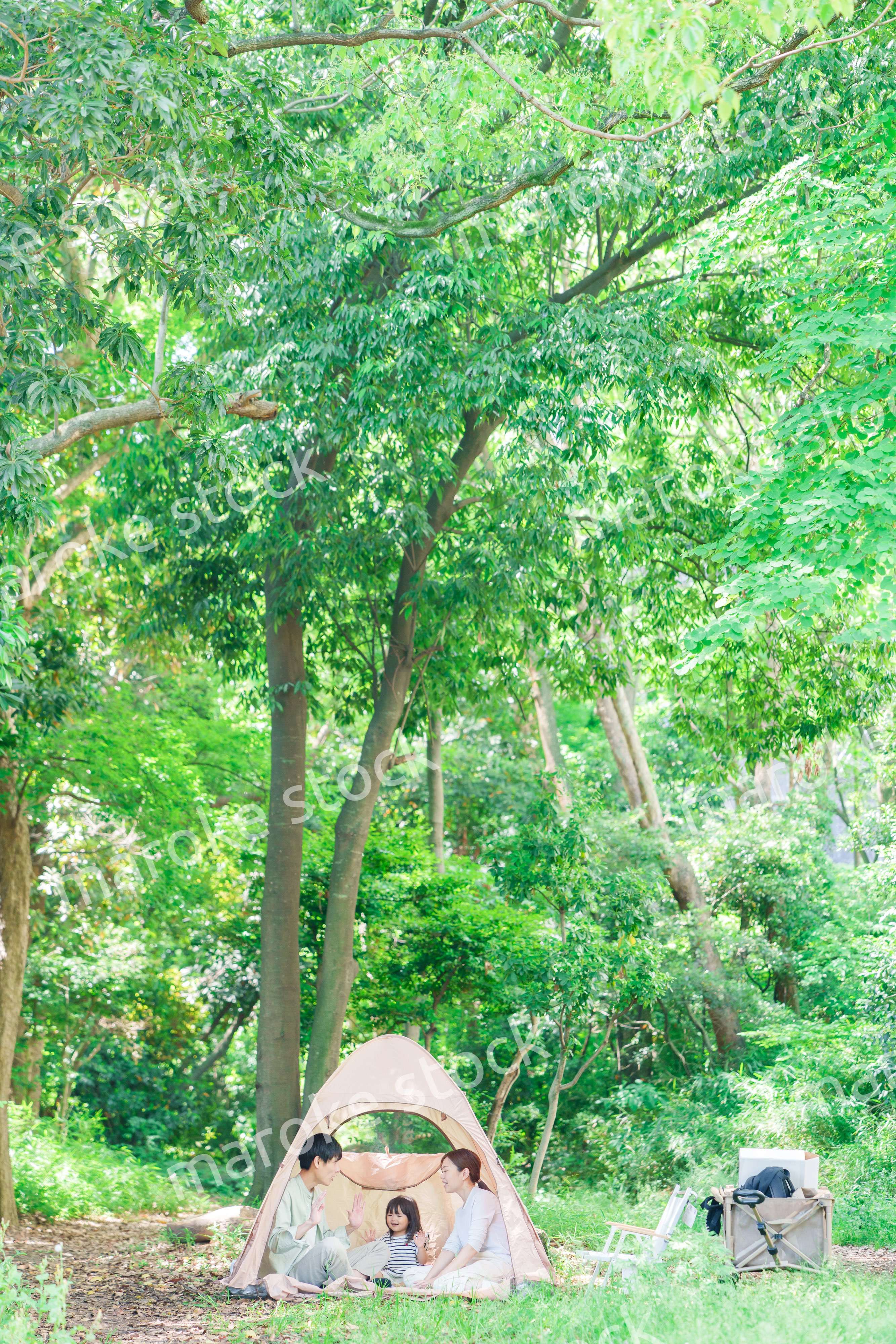 森の中でキャンプを楽しむ子供連れのファミリー