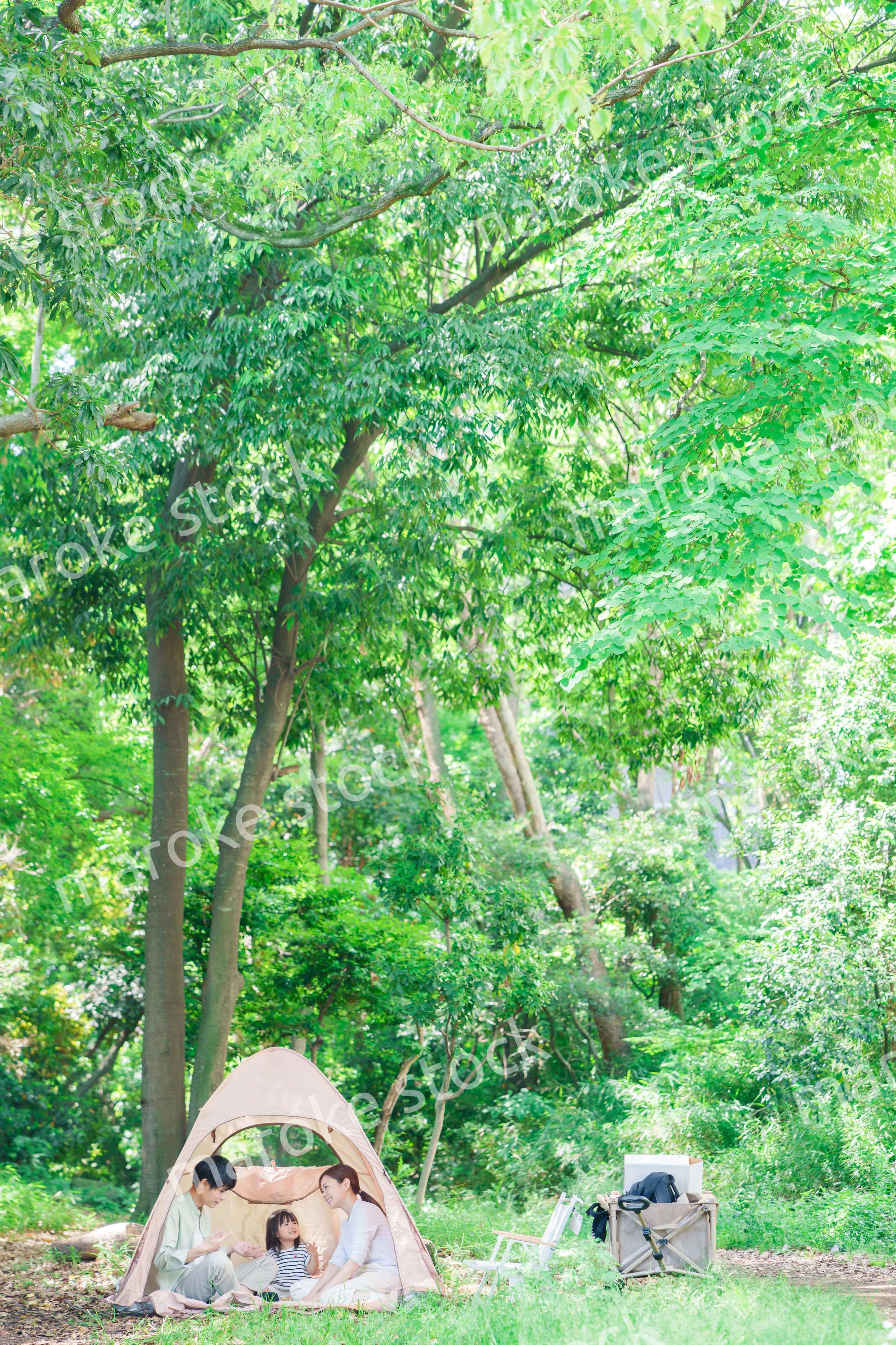 森の中でキャンプを楽しむ子供連れのファミリー