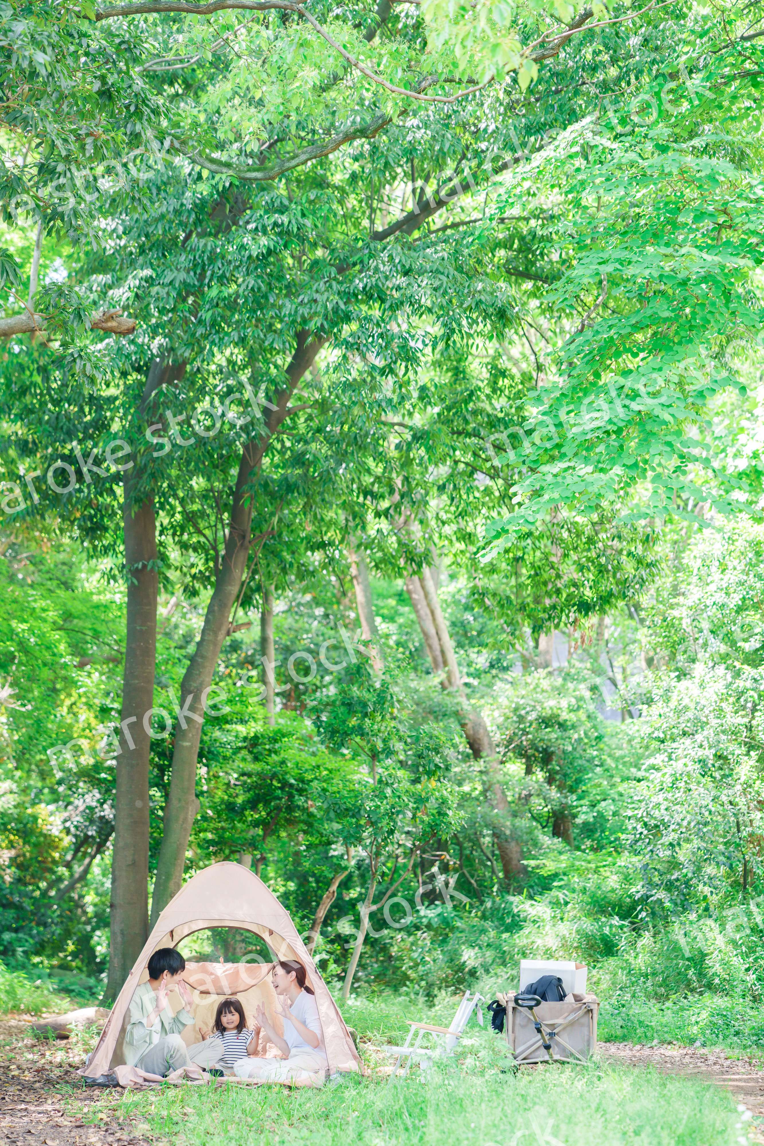 森の中でキャンプを楽しむ子供連れのファミリー