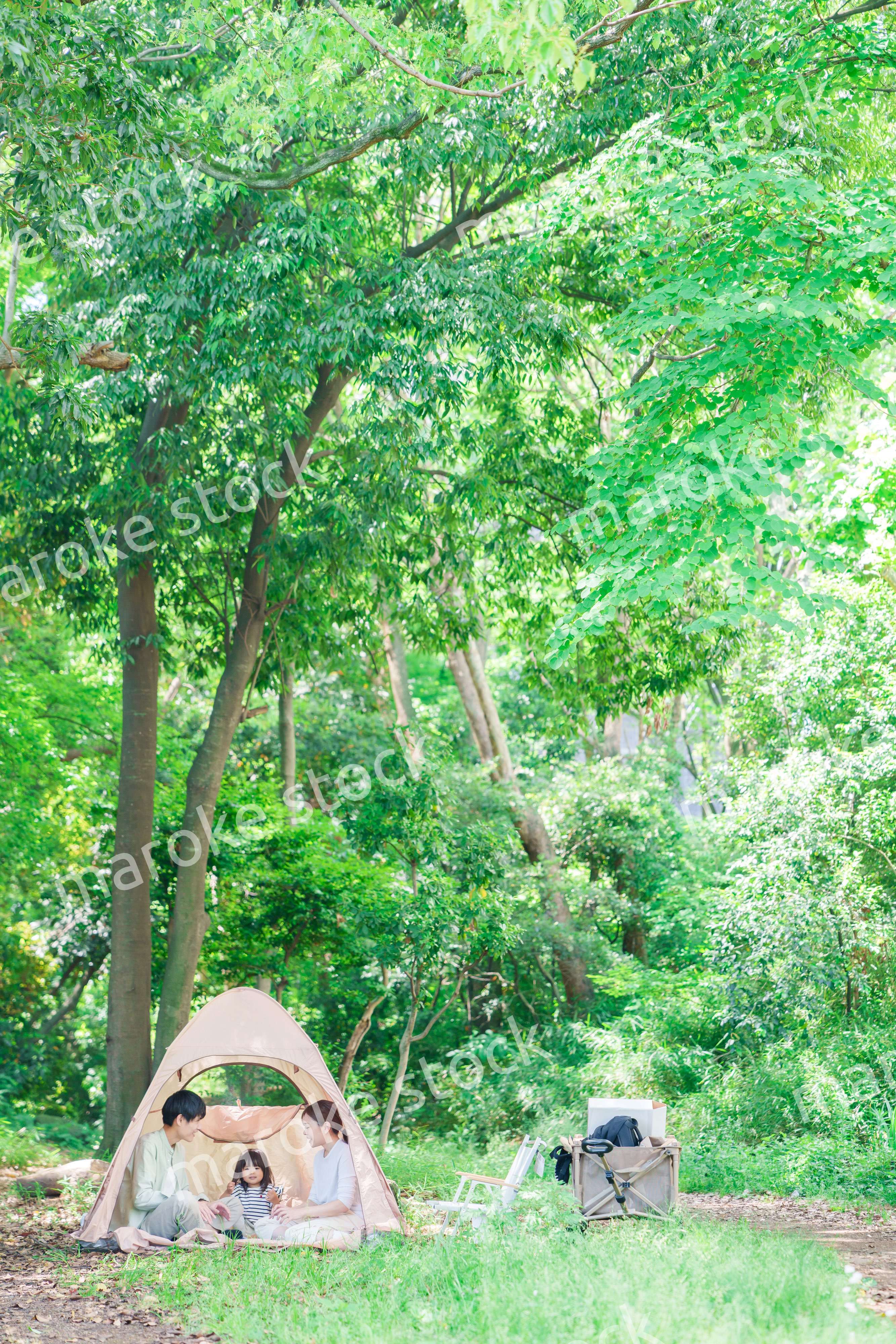 森の中でキャンプを楽しむ子供連れのファミリー