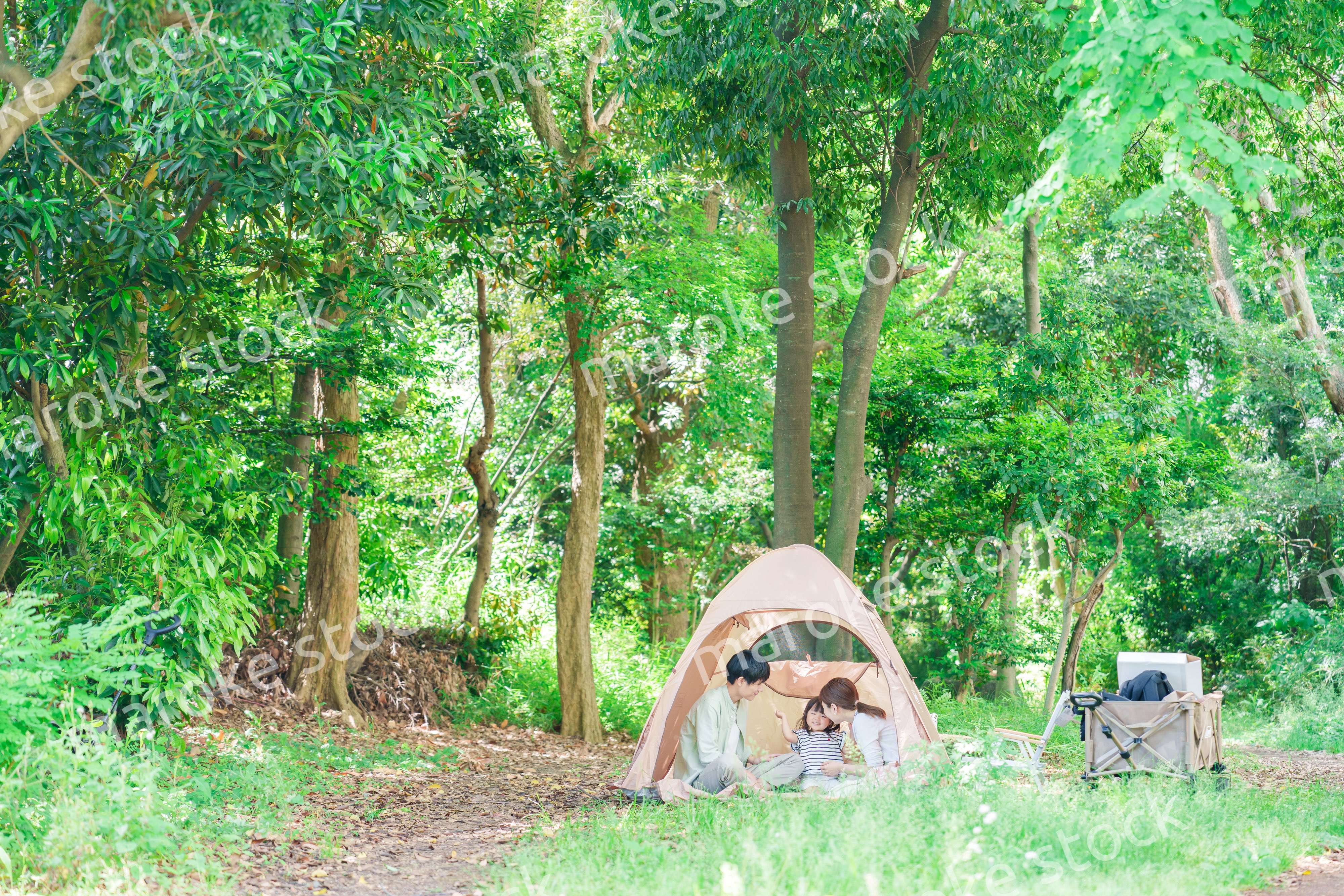 森の中でキャンプを楽しむ子供連れのファミリー