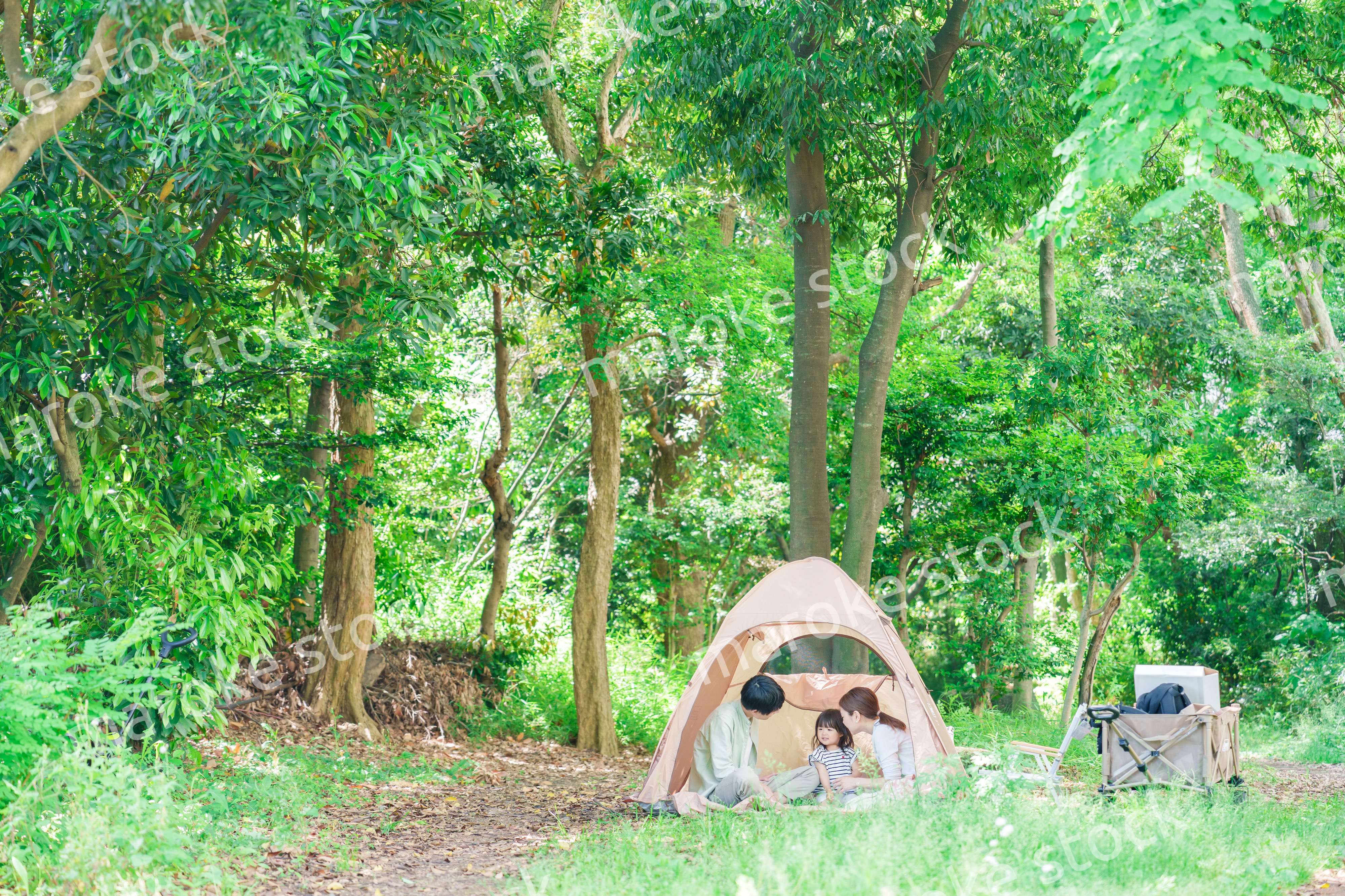 森の中でキャンプを楽しむ子供連れのファミリー