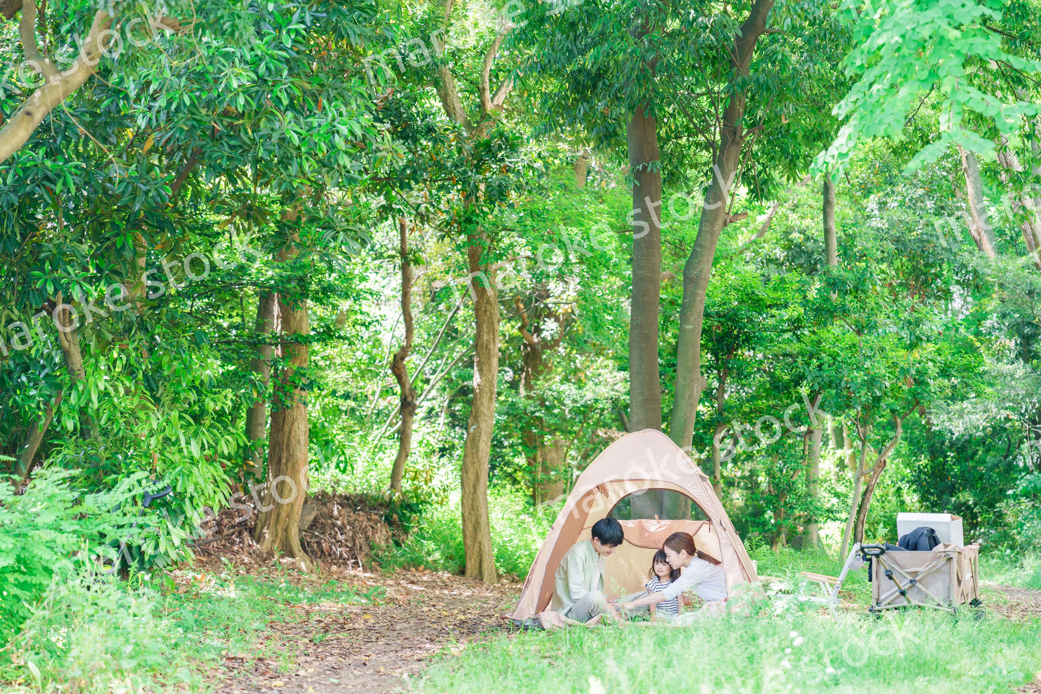 森の中でキャンプを楽しむ子供連れのファミリー