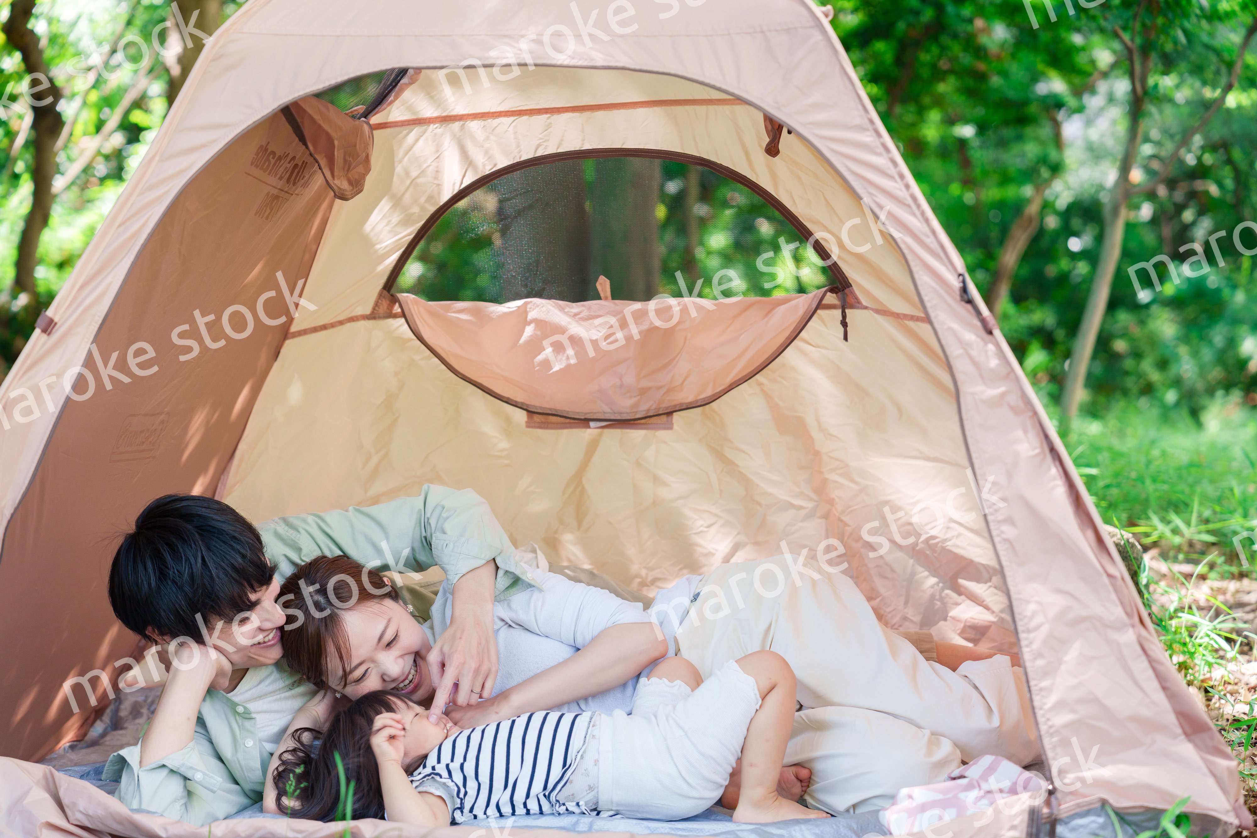 森の中でキャンプを楽しむ子供連れのファミリー
