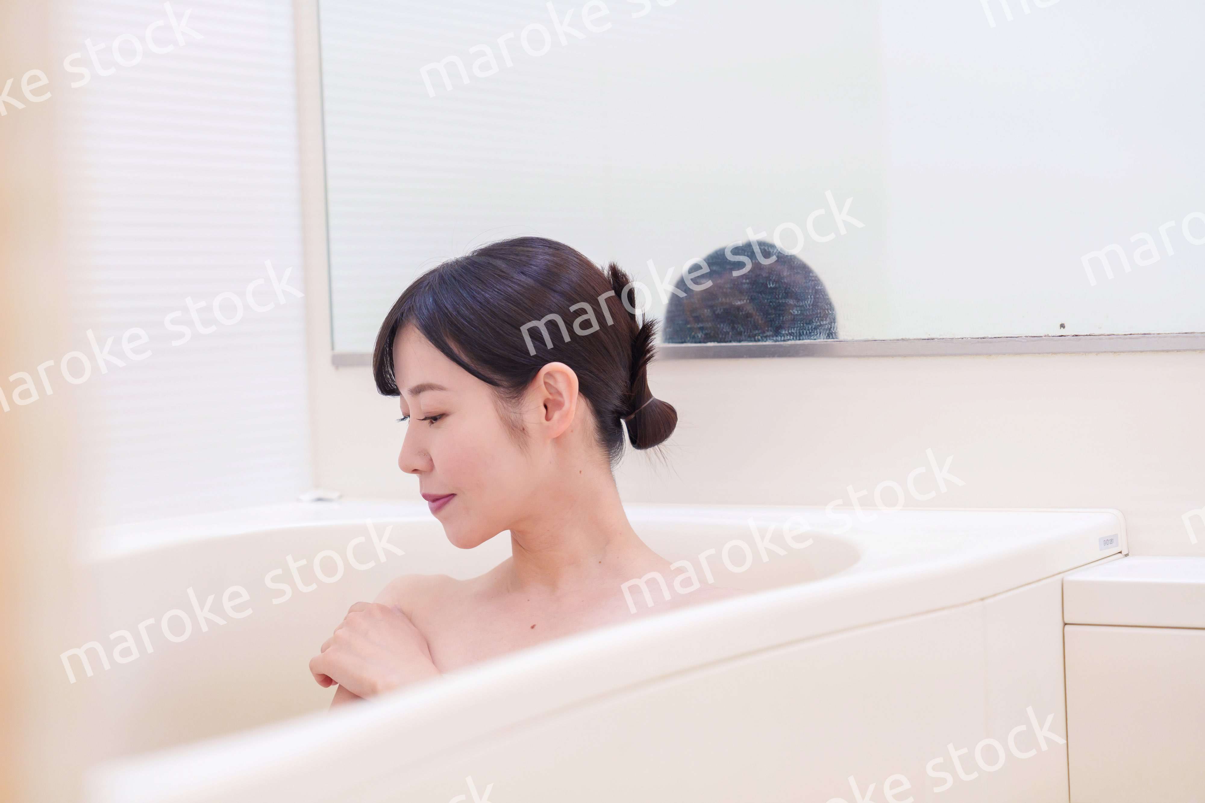 家のお風呂に入ってゆっくりとリラックスをするミドルの女性