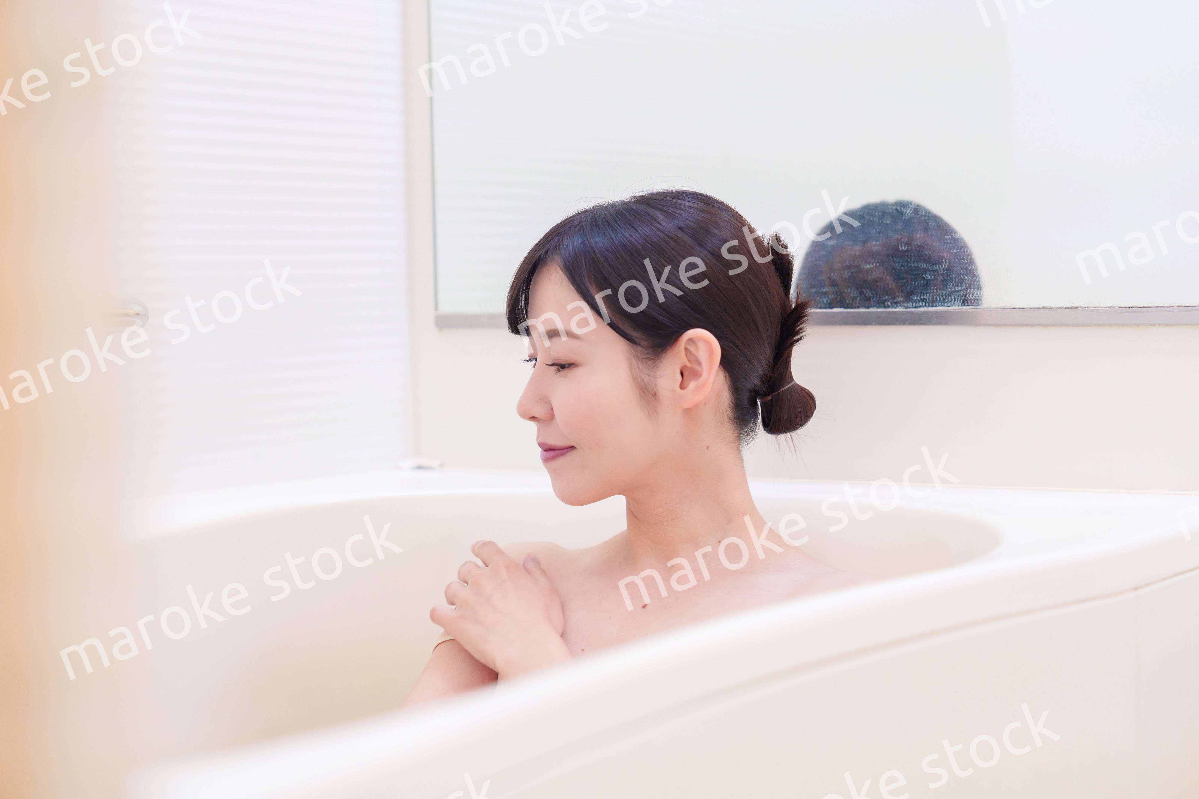 家のお風呂に入ってゆっくりとリラックスをするミドルの女性