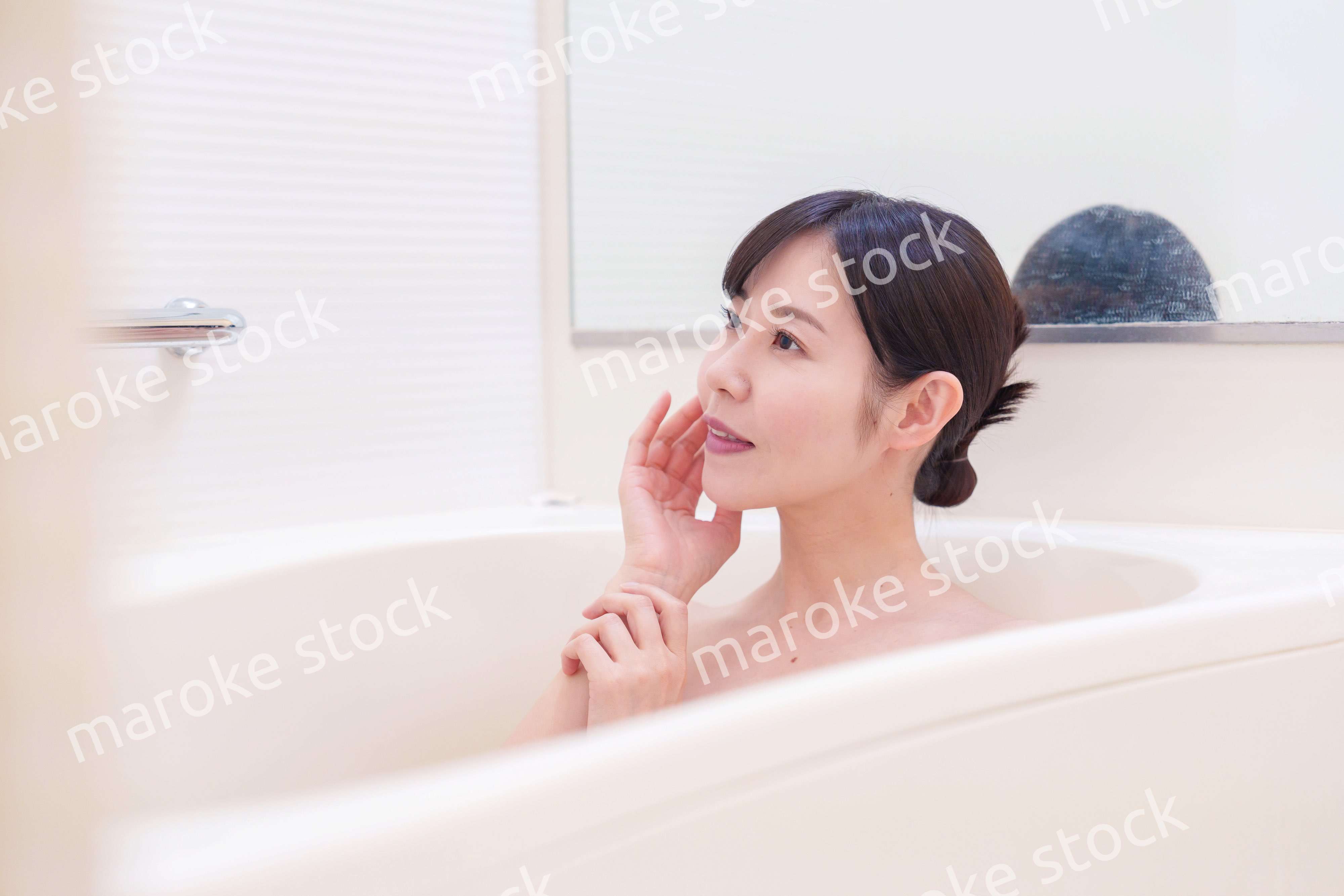 家のお風呂に入ってゆっくりとリラックスをするミドルの女性